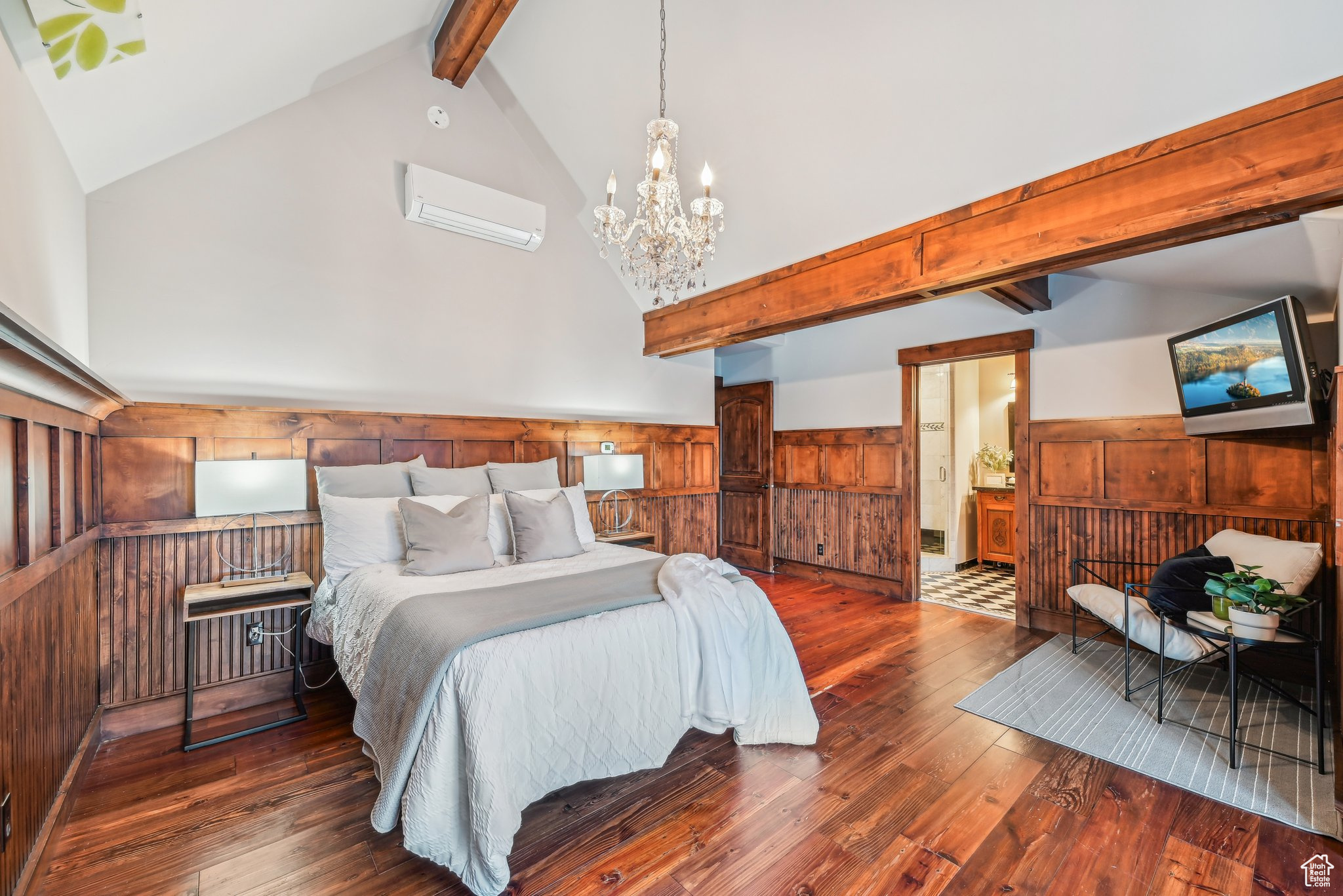 Bedroom featuring lofted ceiling with beams, a wall mounted AC, dark wood-type flooring, and wood walls