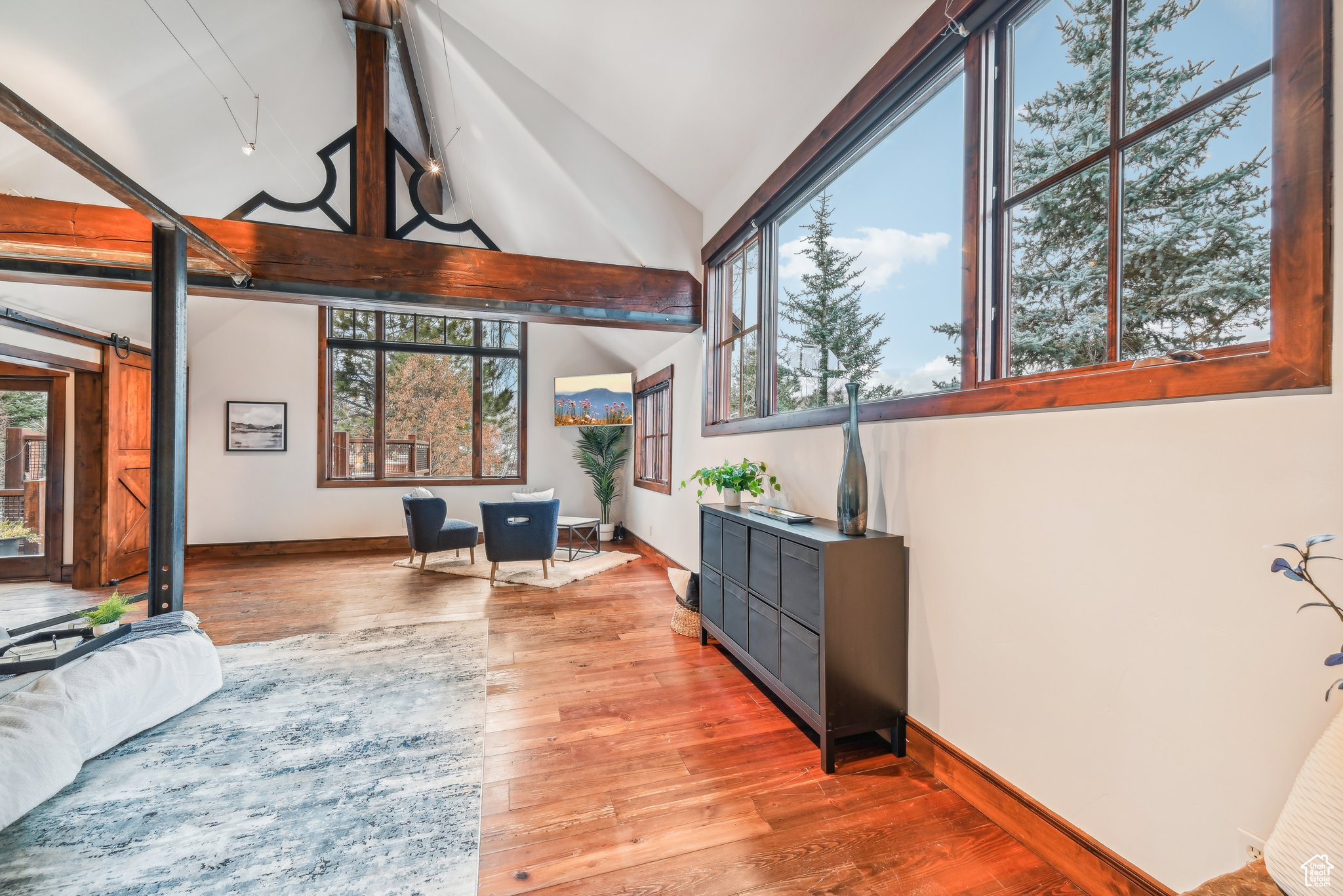 Living room featuring a wealth of natural light, light hardwood / wood-style floors, and lofted ceiling