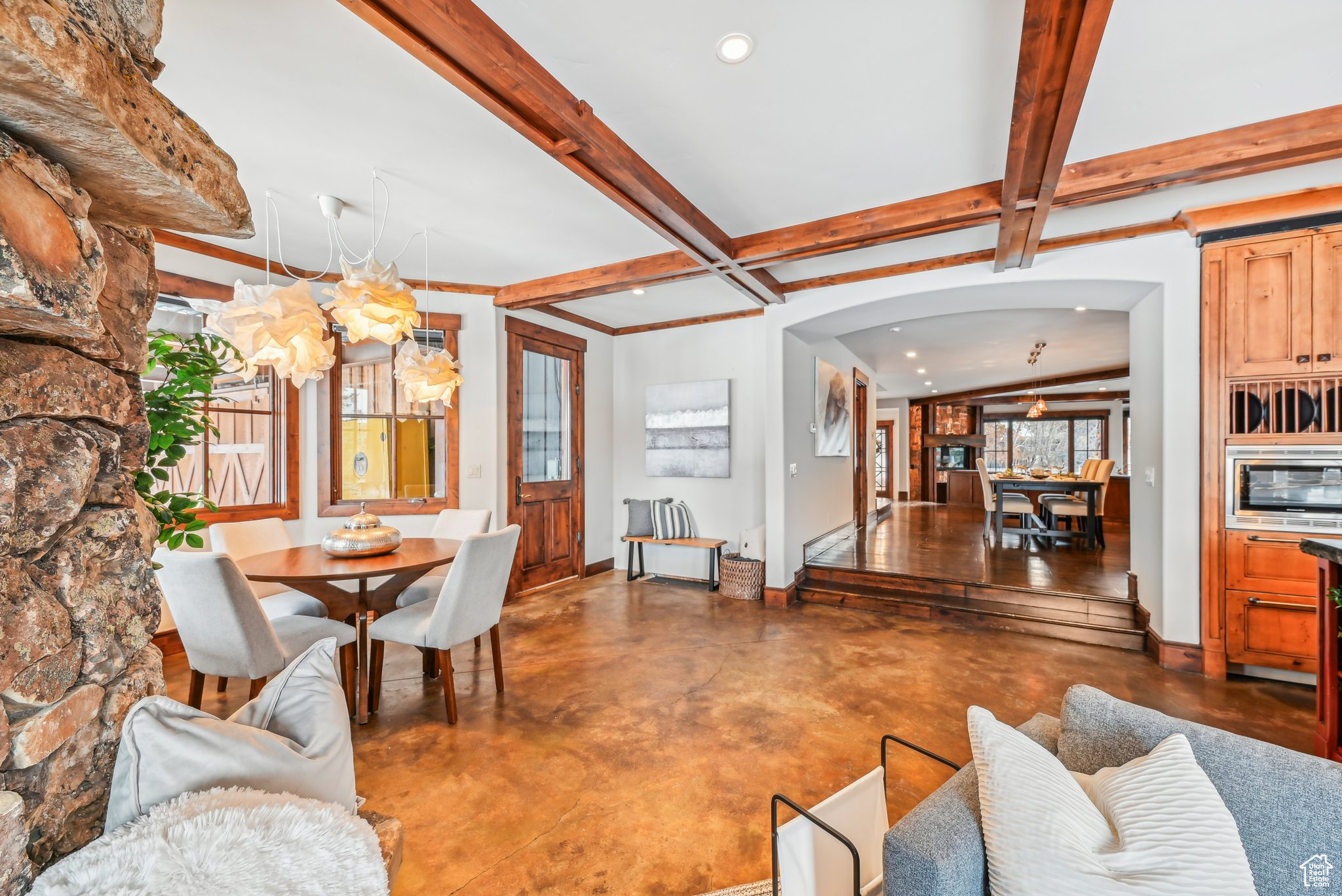 Living room featuring concrete flooring, beam ceiling, and coffered ceiling