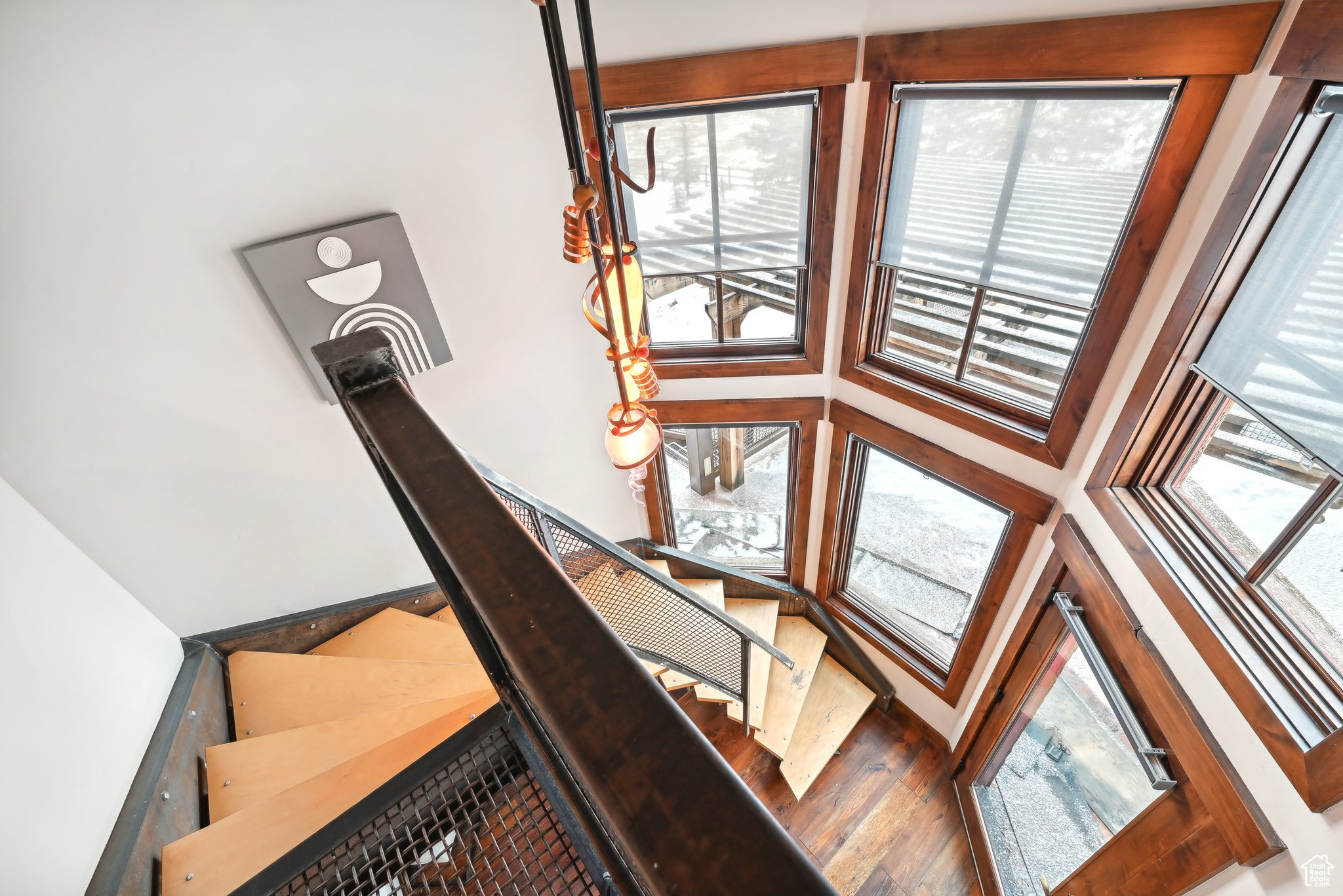 Stairway with wood-type flooring and a high ceiling