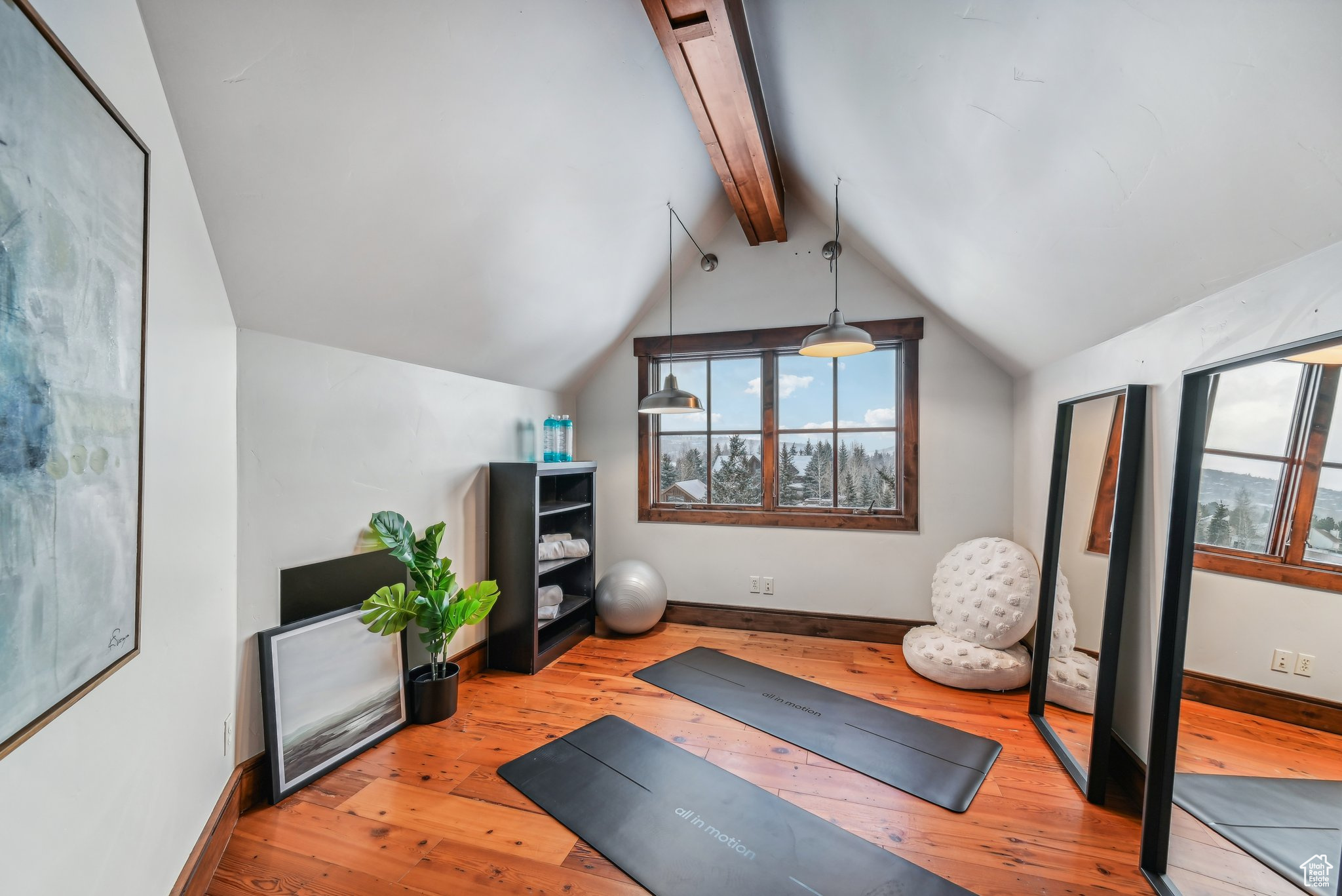 Exercise area with lofted ceiling and light wood-type flooring