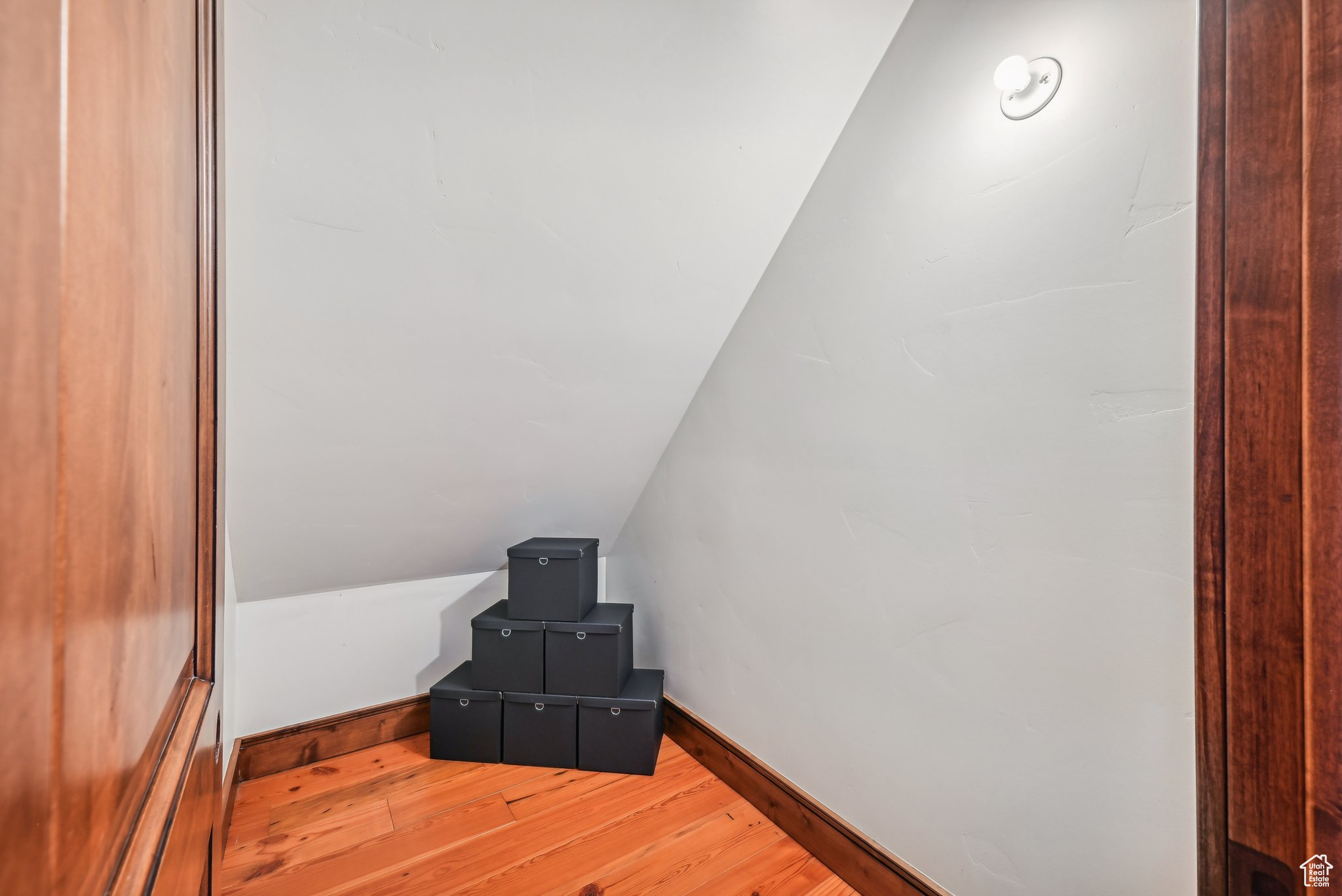 Additional living space featuring wood-type flooring and lofted ceiling