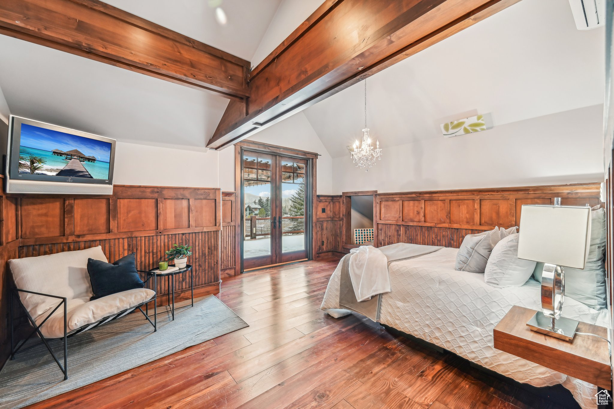 Bedroom featuring access to exterior, french doors, lofted ceiling with beams, a chandelier, and hardwood / wood-style floors