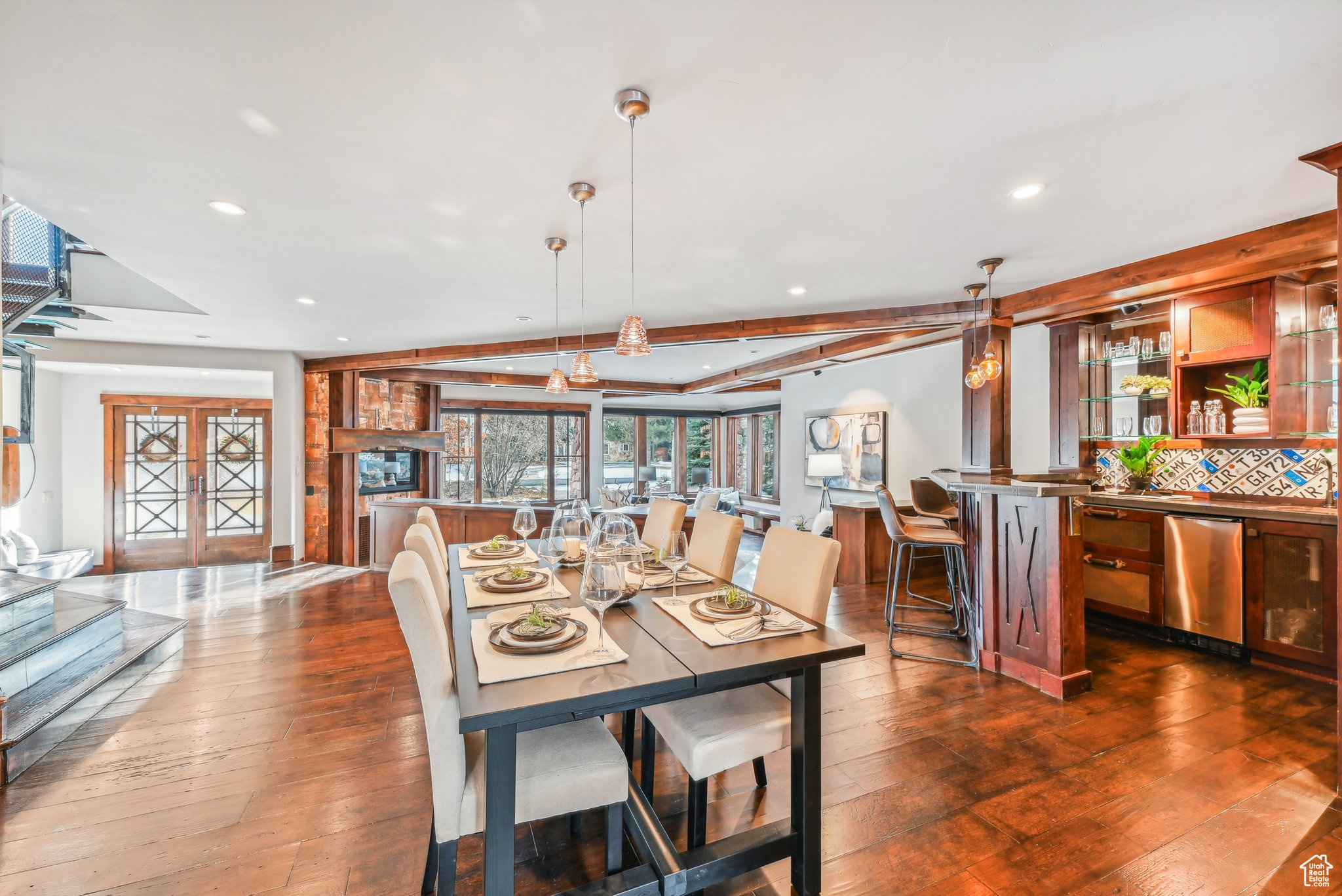 Dining space with beam ceiling, french doors, and dark hardwood / wood-style floors