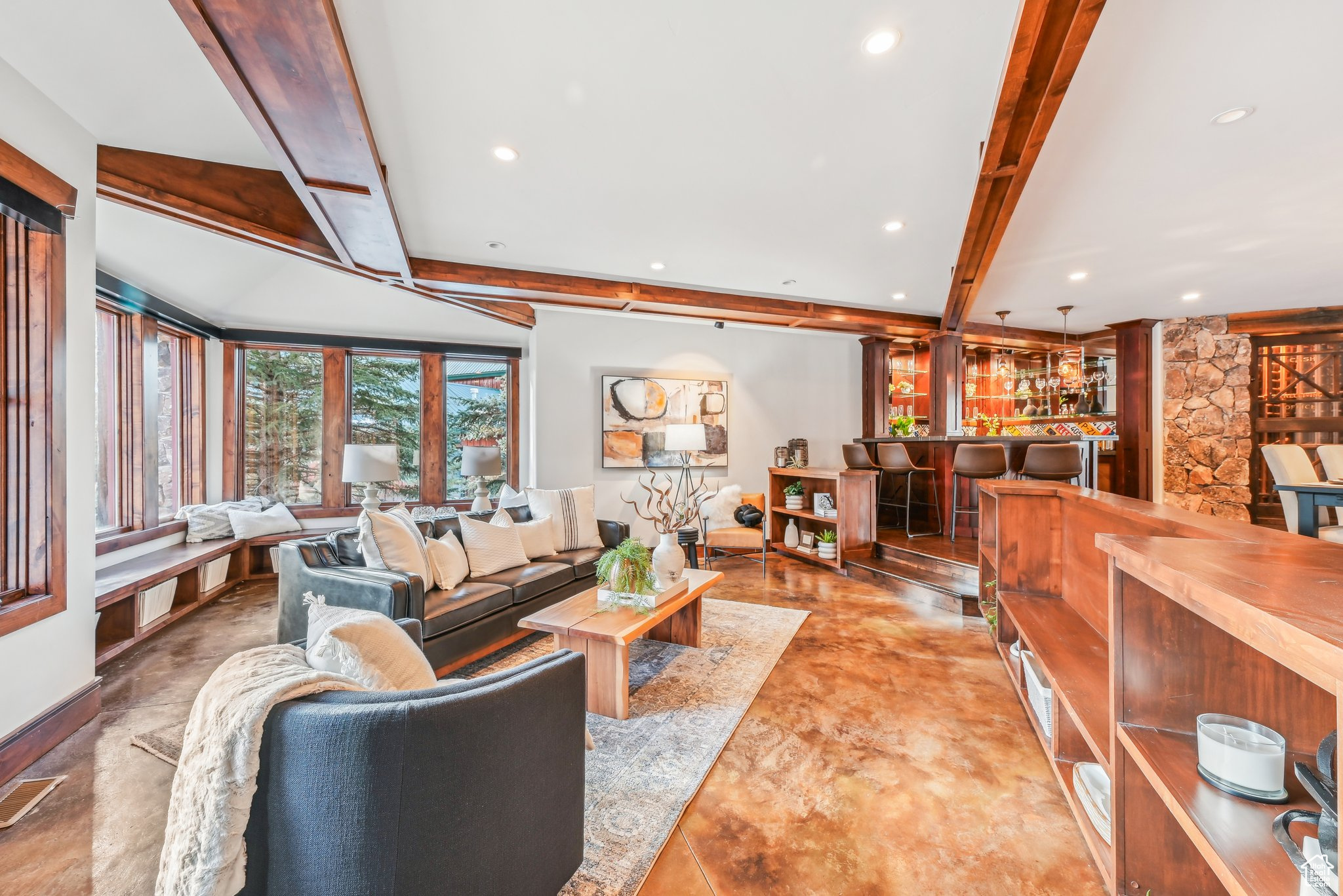 Living room featuring beam ceiling and bar area