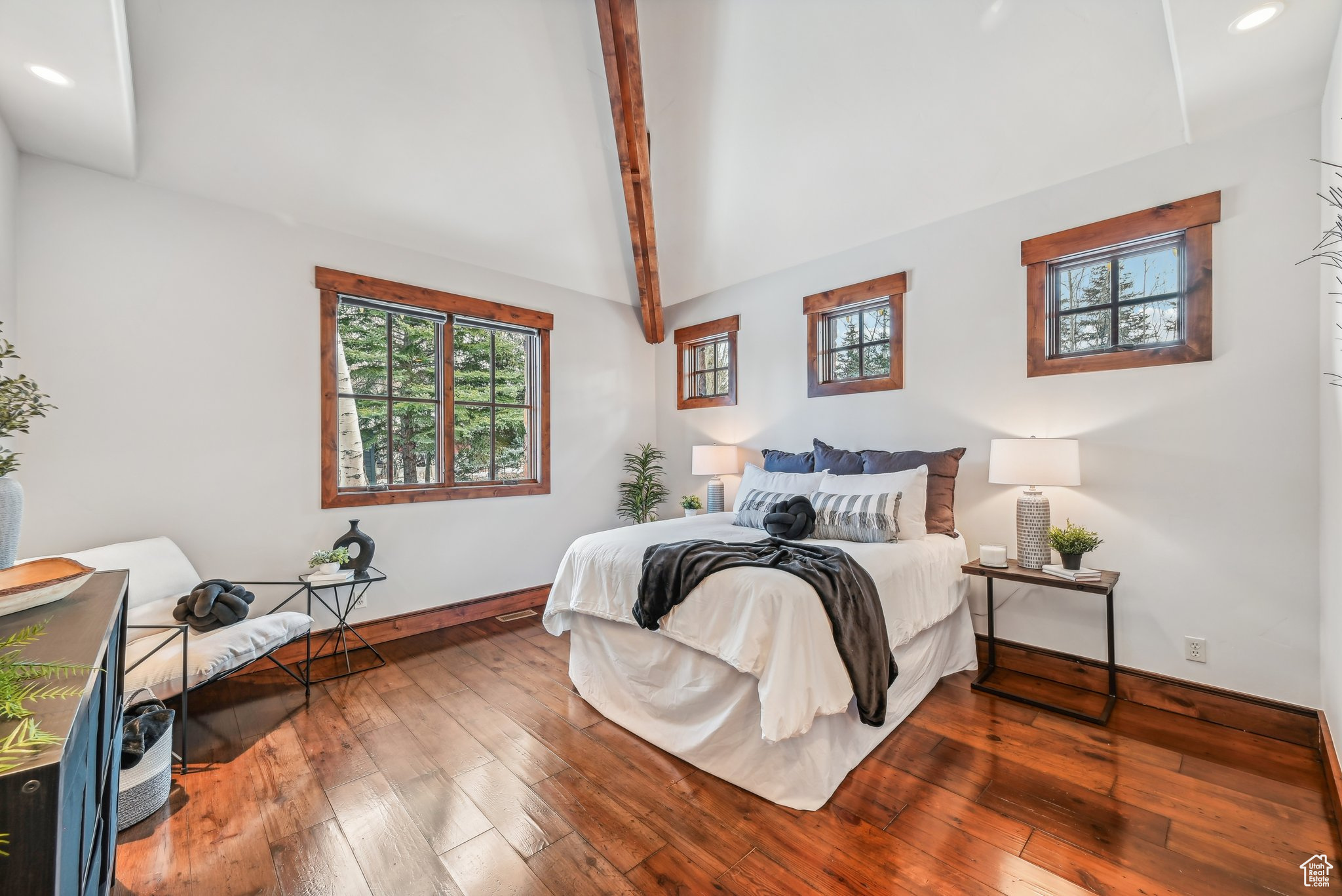 Bedroom with lofted ceiling with beams and wood-type flooring