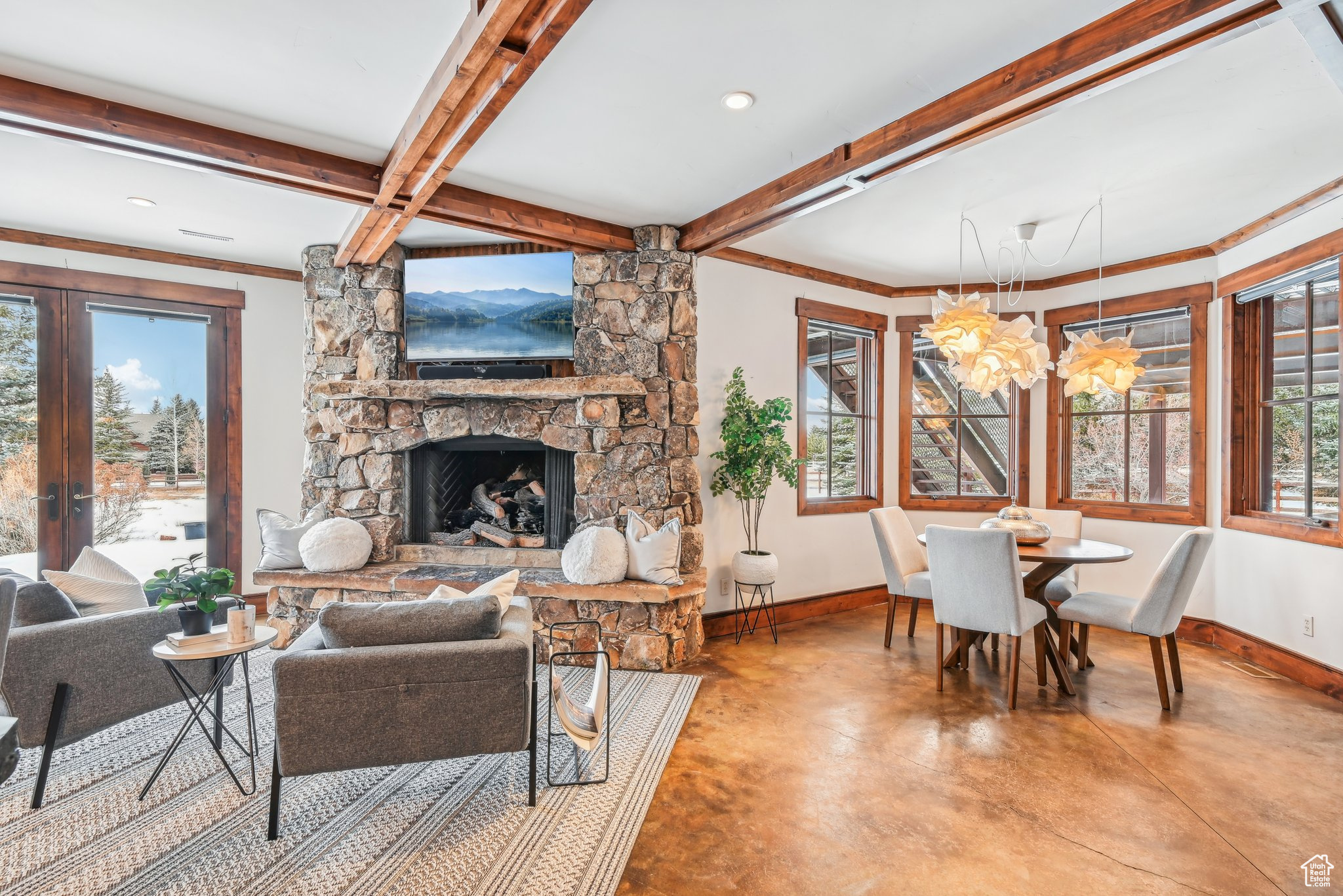 Living room with a fireplace, ornamental molding, a chandelier, and beamed ceiling