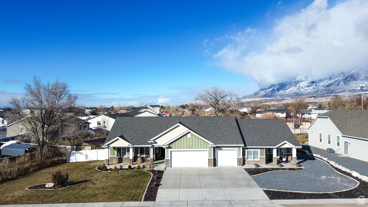 View of front facade featuring a mountain view, a front lawn, and a garage