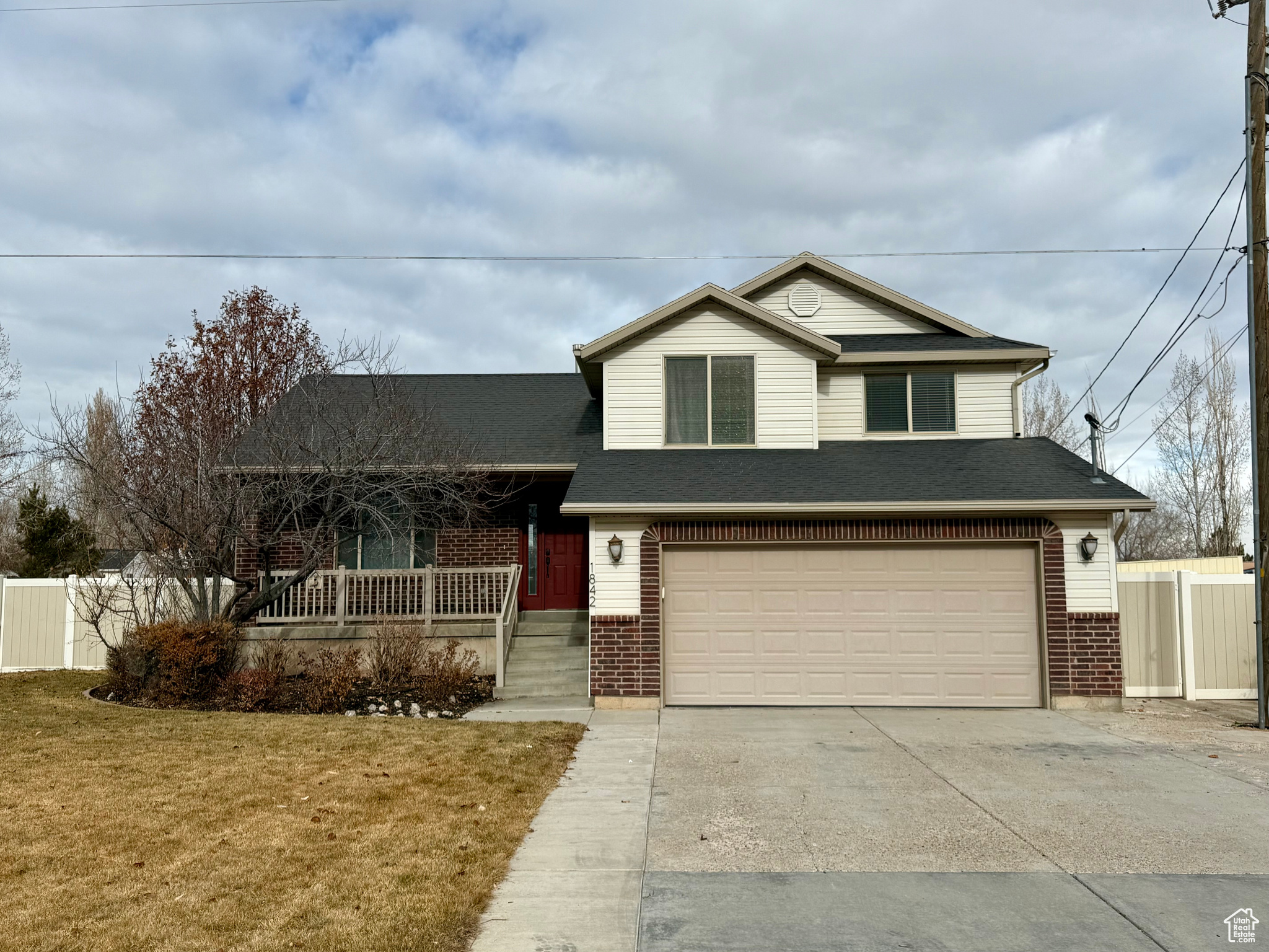 View of front of property featuring a front yard, a porch, and a garage