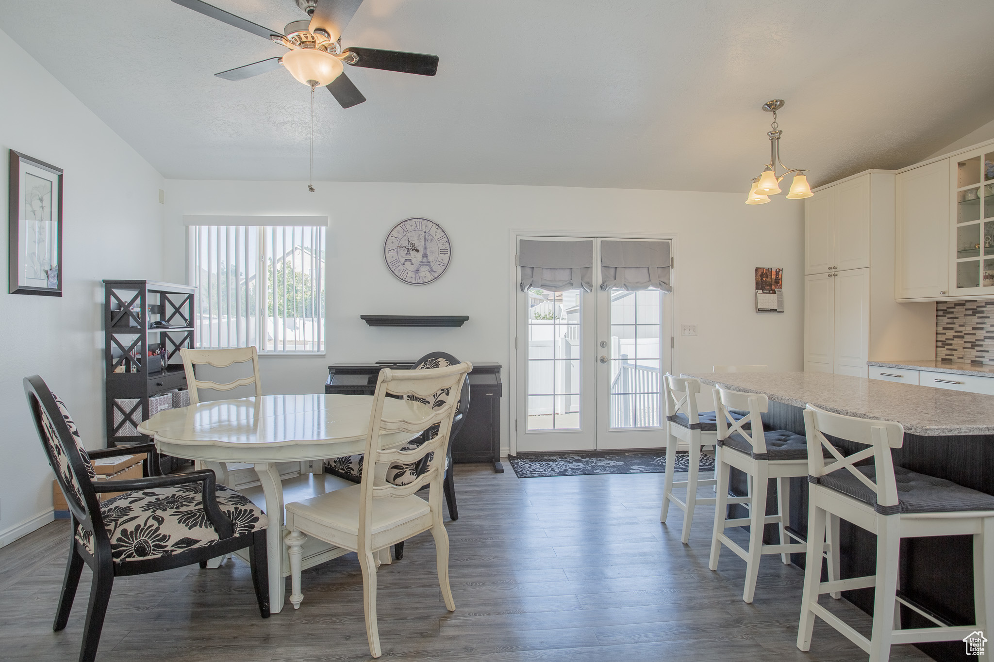 Dining space featuring plenty of natural light, dark wood-type flooring, ceiling fan with notable chandelier, and french doors