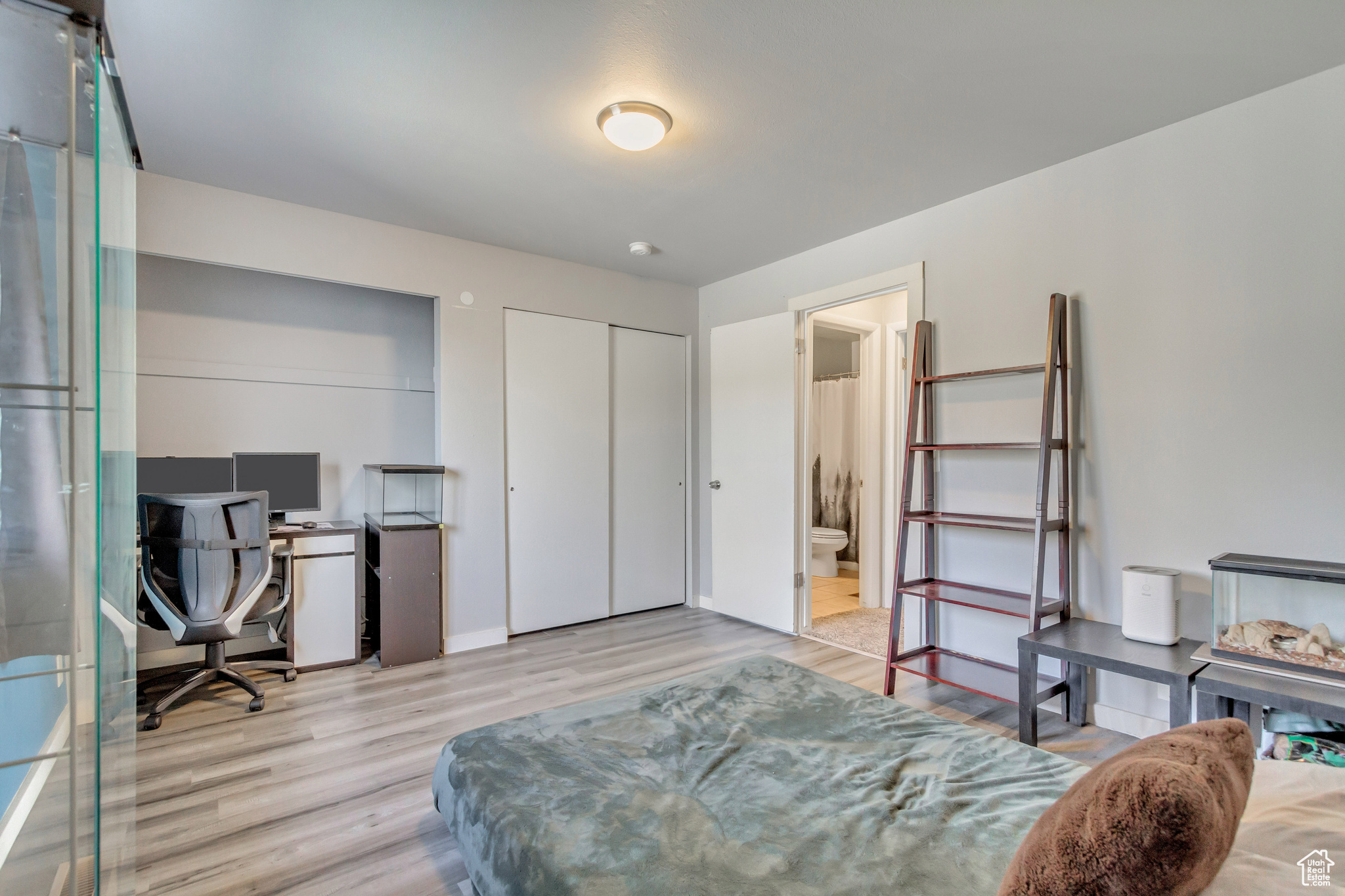 Bedroom featuring connected bathroom, a closet, and light hardwood / wood-style floors