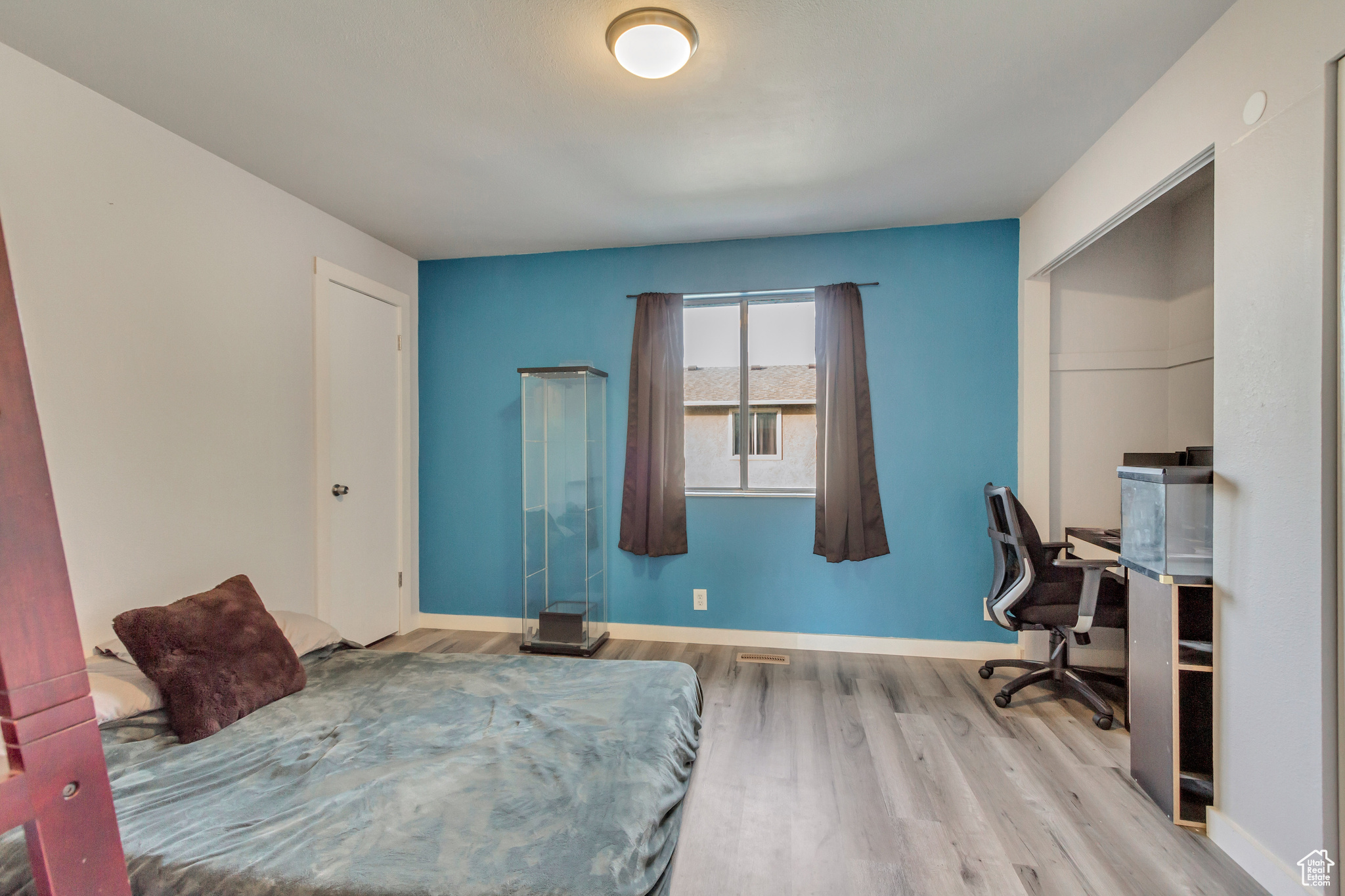 Bedroom with light hardwood / wood-style floors and a closet