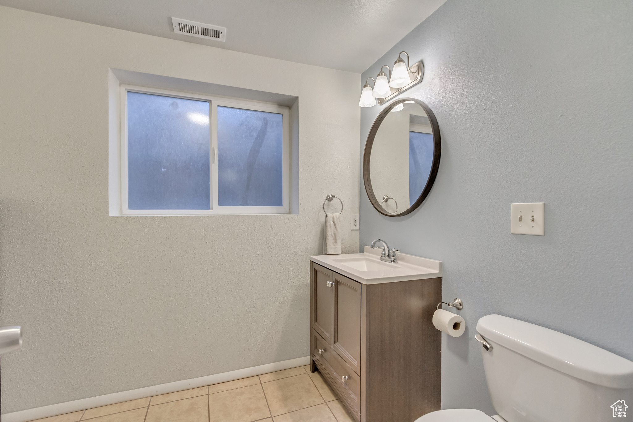 Bathroom featuring tile patterned flooring, vanity, and toilet