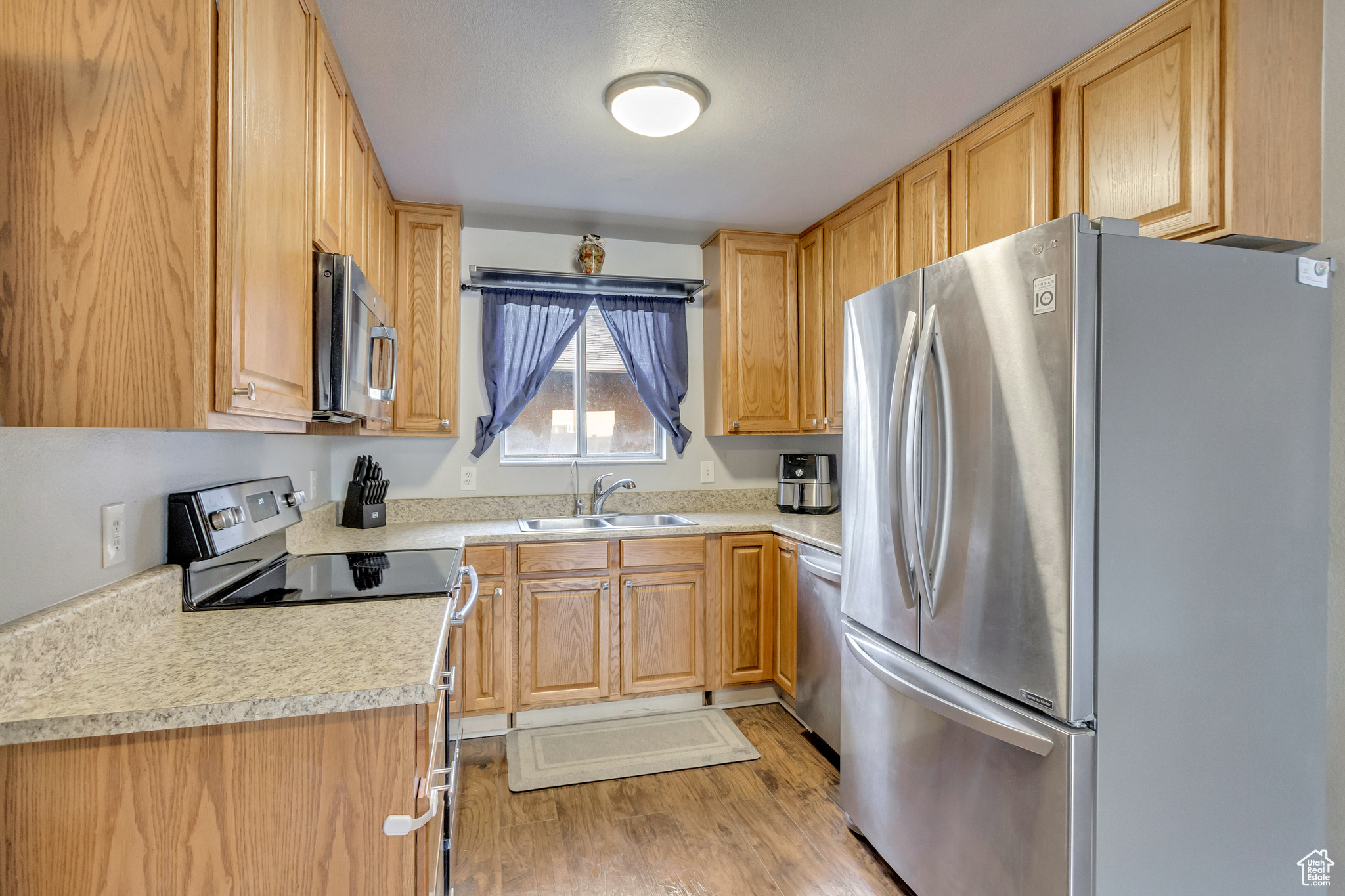 Kitchen featuring appliances with stainless steel finishes, light hardwood / wood-style floors, and sink