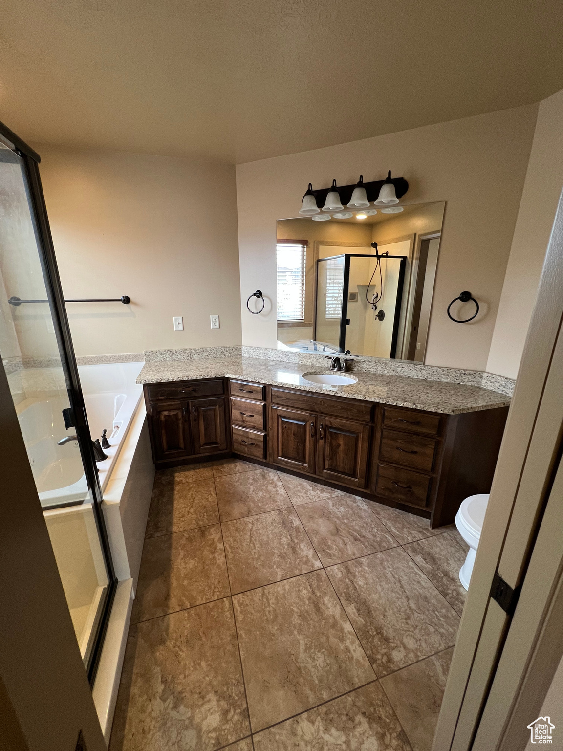 Full bathroom featuring tile patterned floors, vanity, separate shower and tub, and toilet