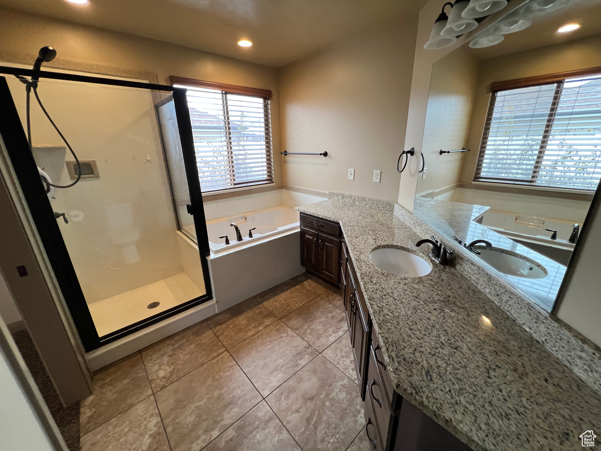 Bathroom featuring tile patterned flooring, vanity, and shower with separate bathtub