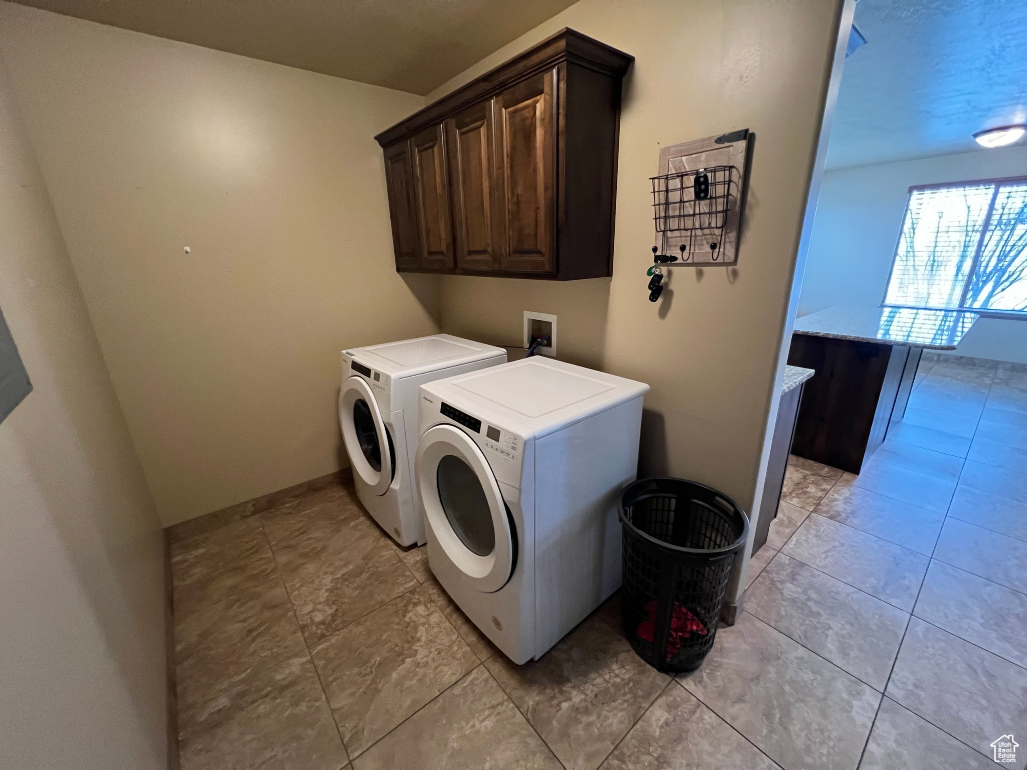 Washroom with cabinets and washer and clothes dryer