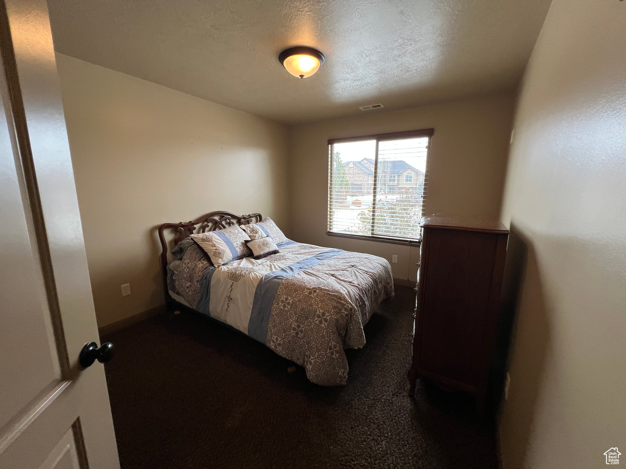 Carpeted bedroom with a textured ceiling