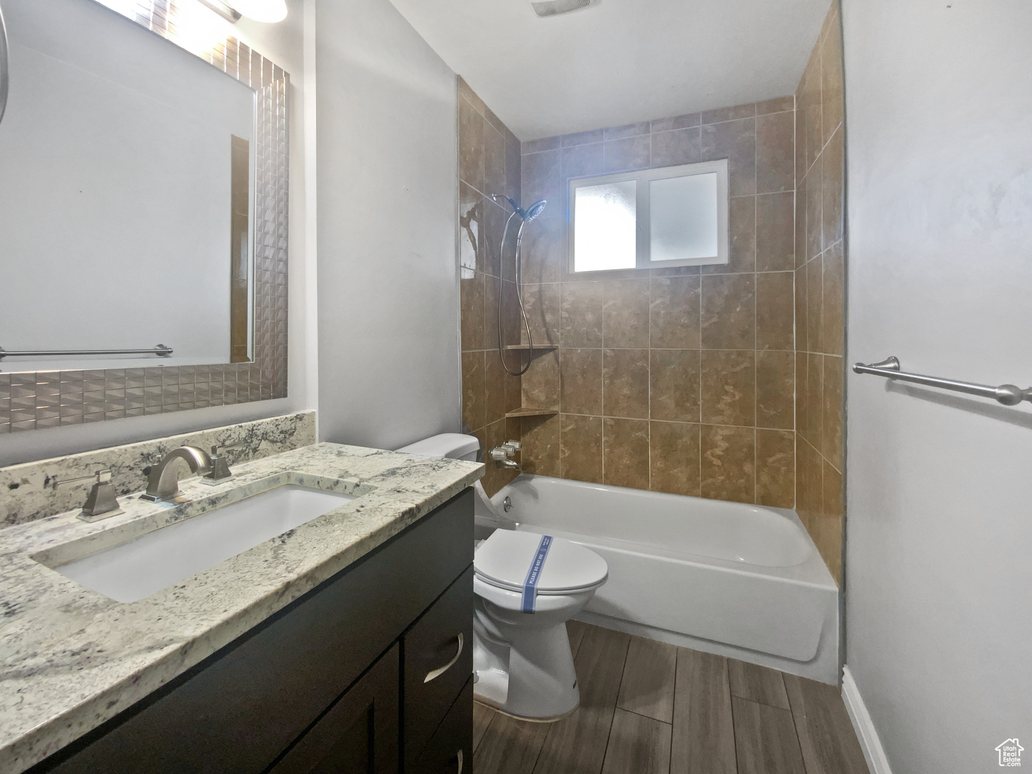 Full bathroom with vanity, toilet, and tiled shower / bath