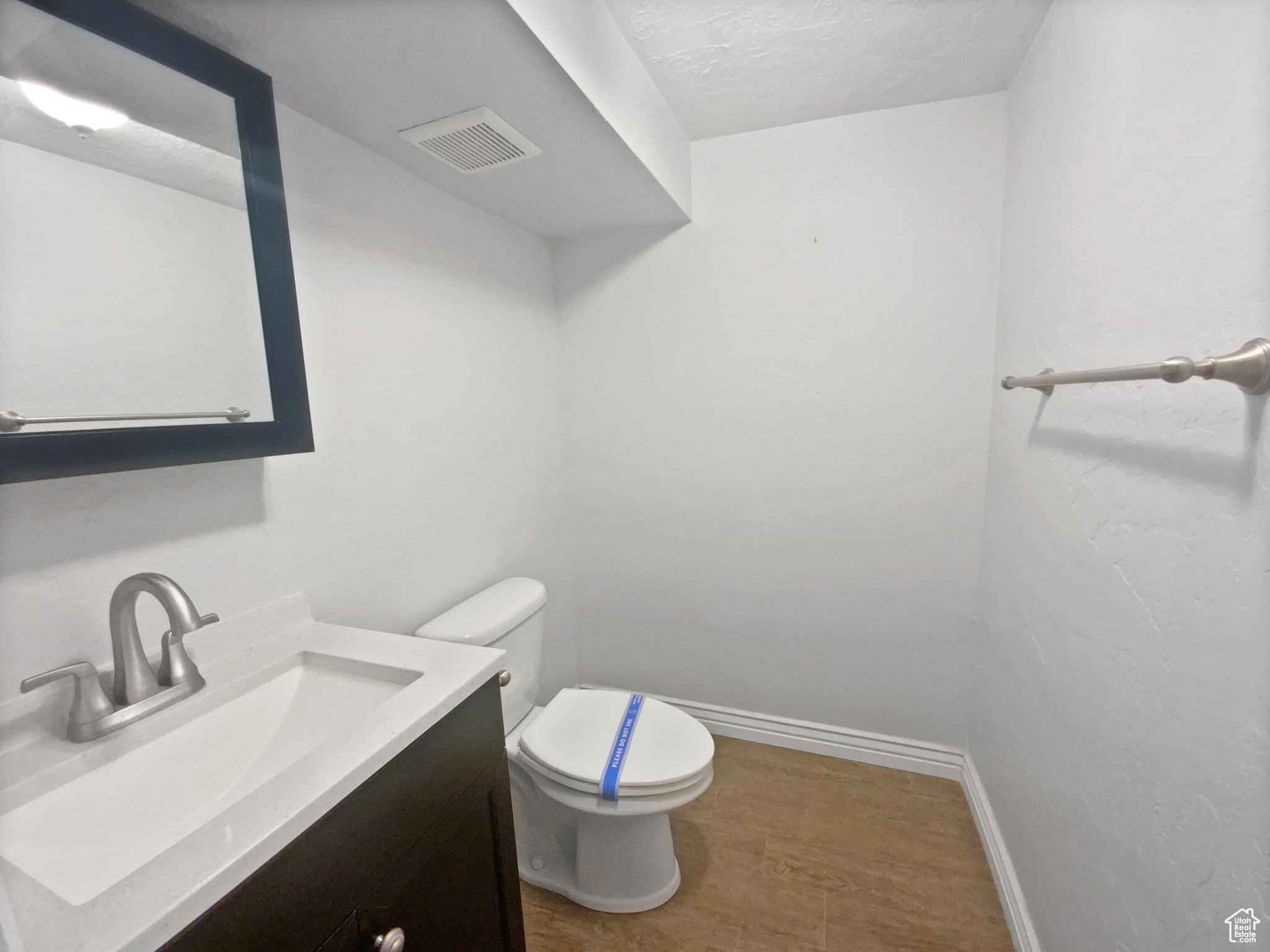 Bathroom featuring vanity, a textured ceiling, and toilet