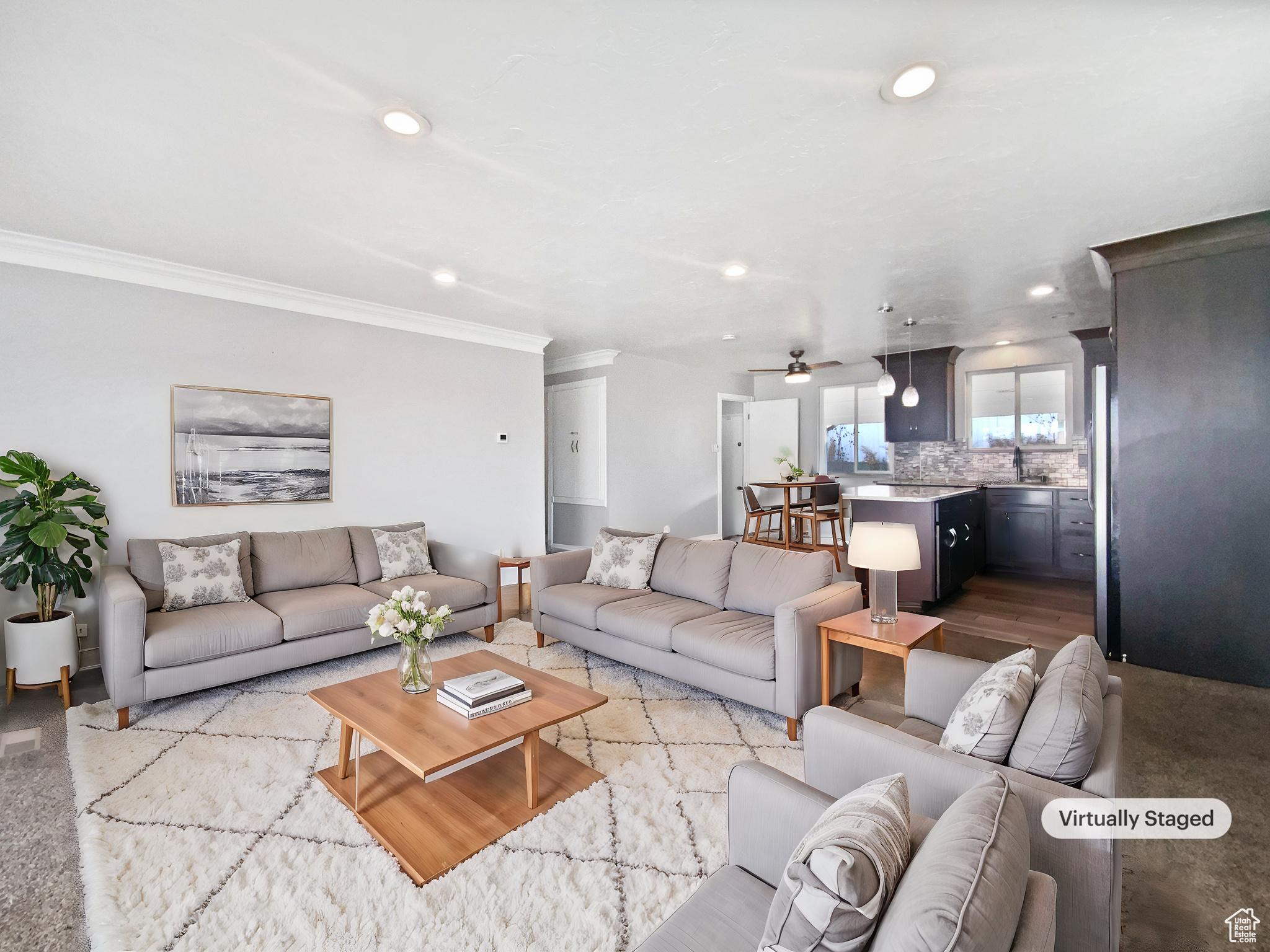 Living room featuring ceiling fan, sink, crown molding, and light hardwood / wood-style floors