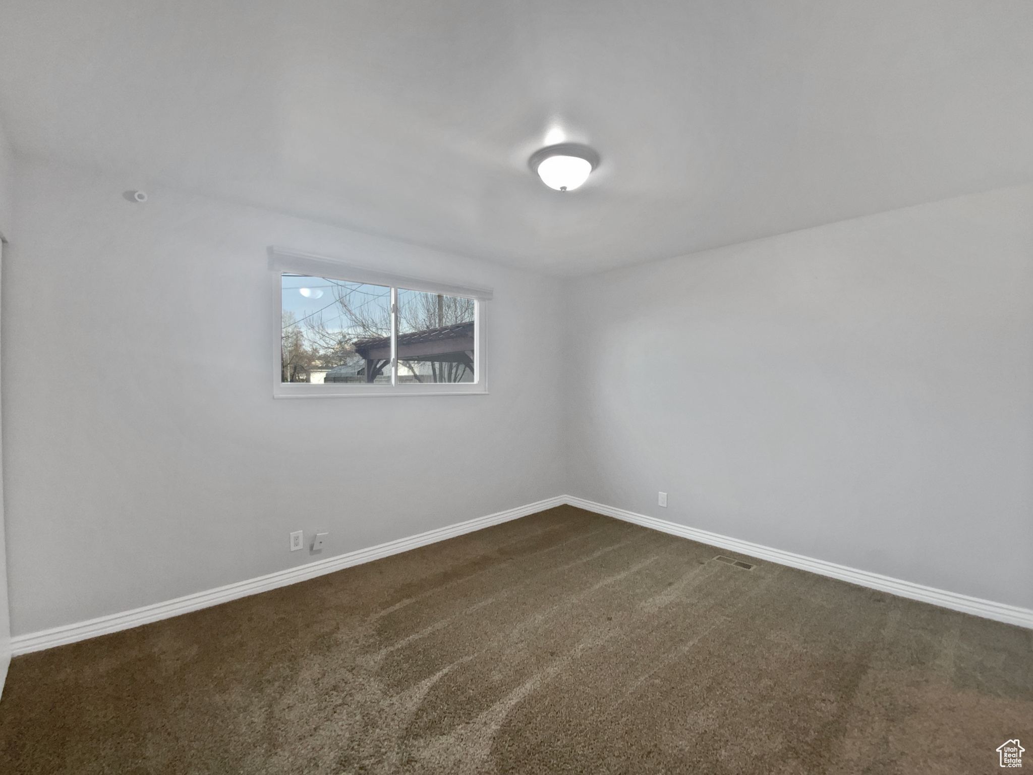 Unfurnished room featuring dark carpet