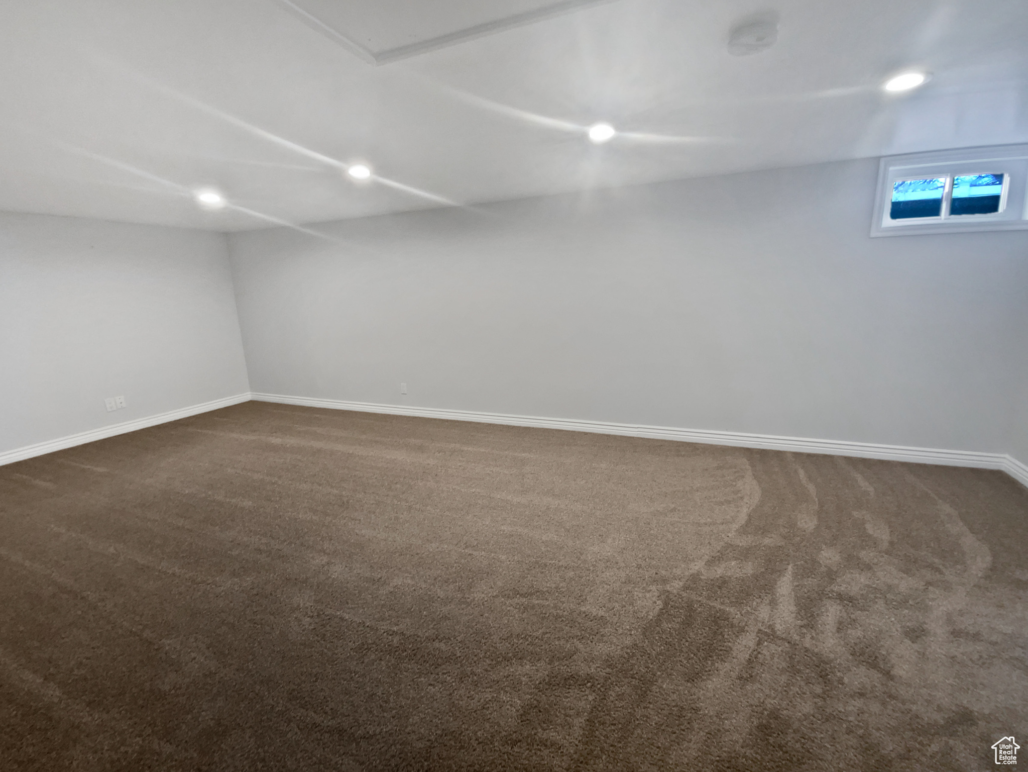 Spare room featuring dark colored carpet