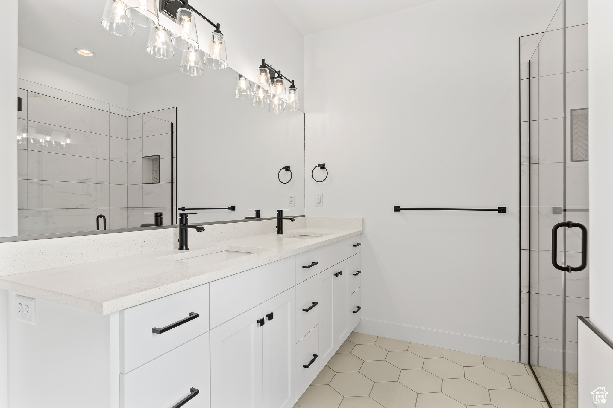 Bathroom with a shower with door, vanity, and tile patterned flooring