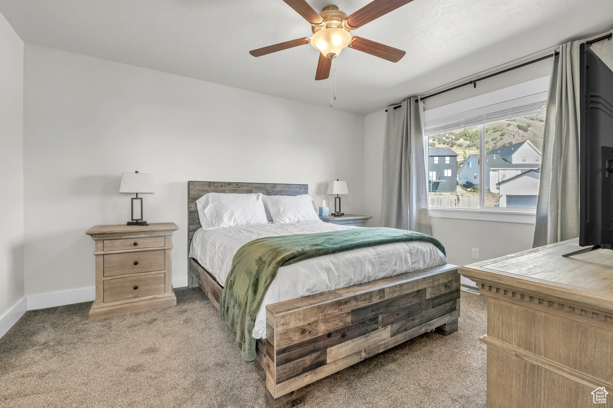 Bedroom with ceiling fan and light carpet