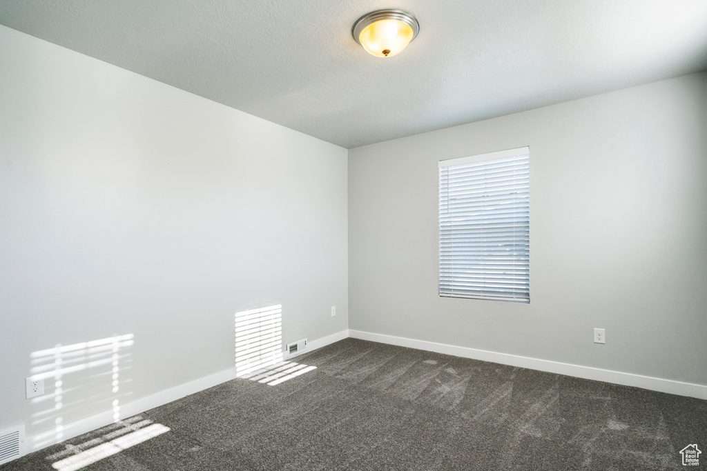 Unfurnished room with dark carpet