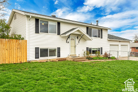 Raised ranch featuring a front yard and a garage