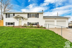 Bi-level home featuring a front yard and a garage