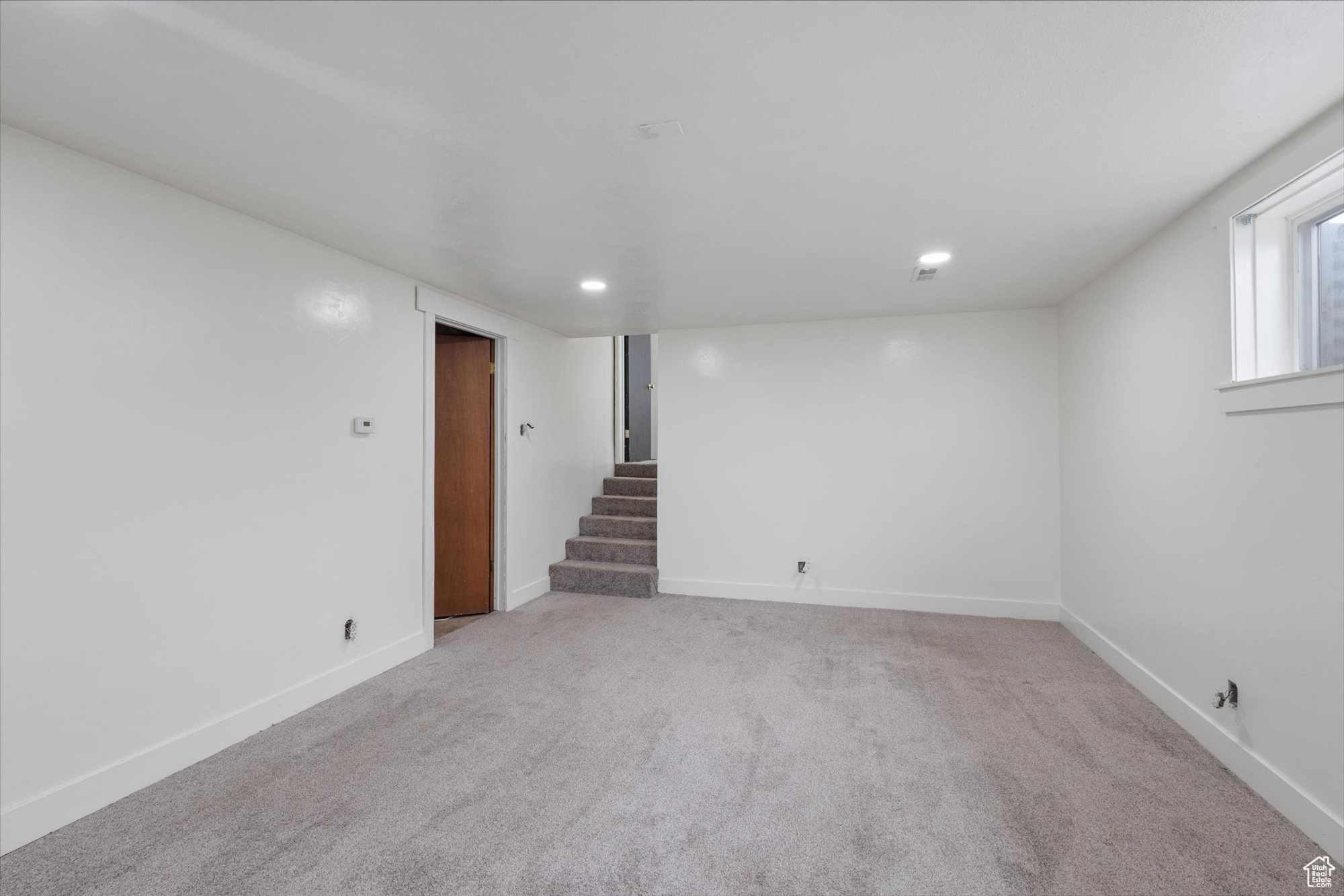 Basement featuring light colored carpet