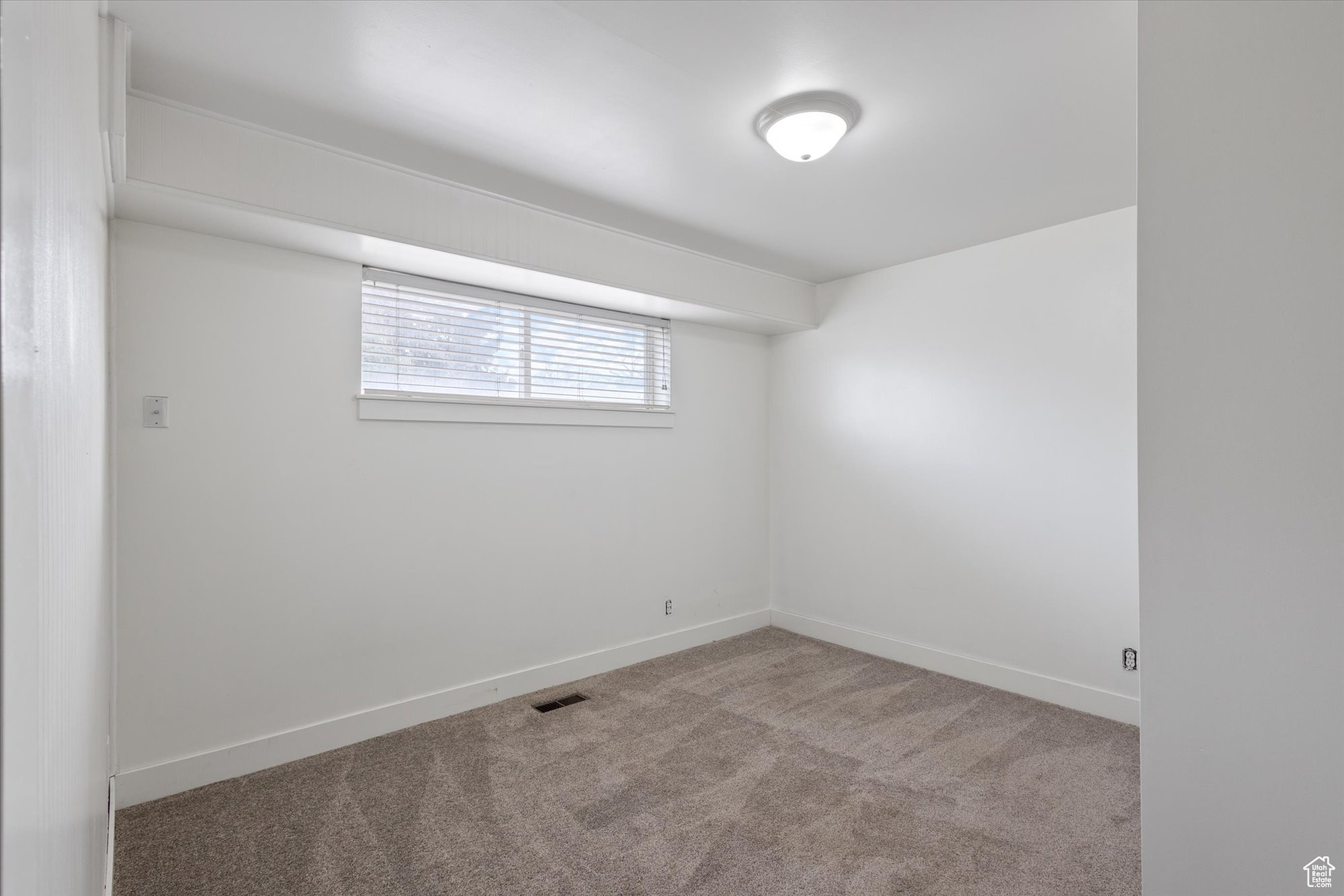 Spare room featuring light colored carpet