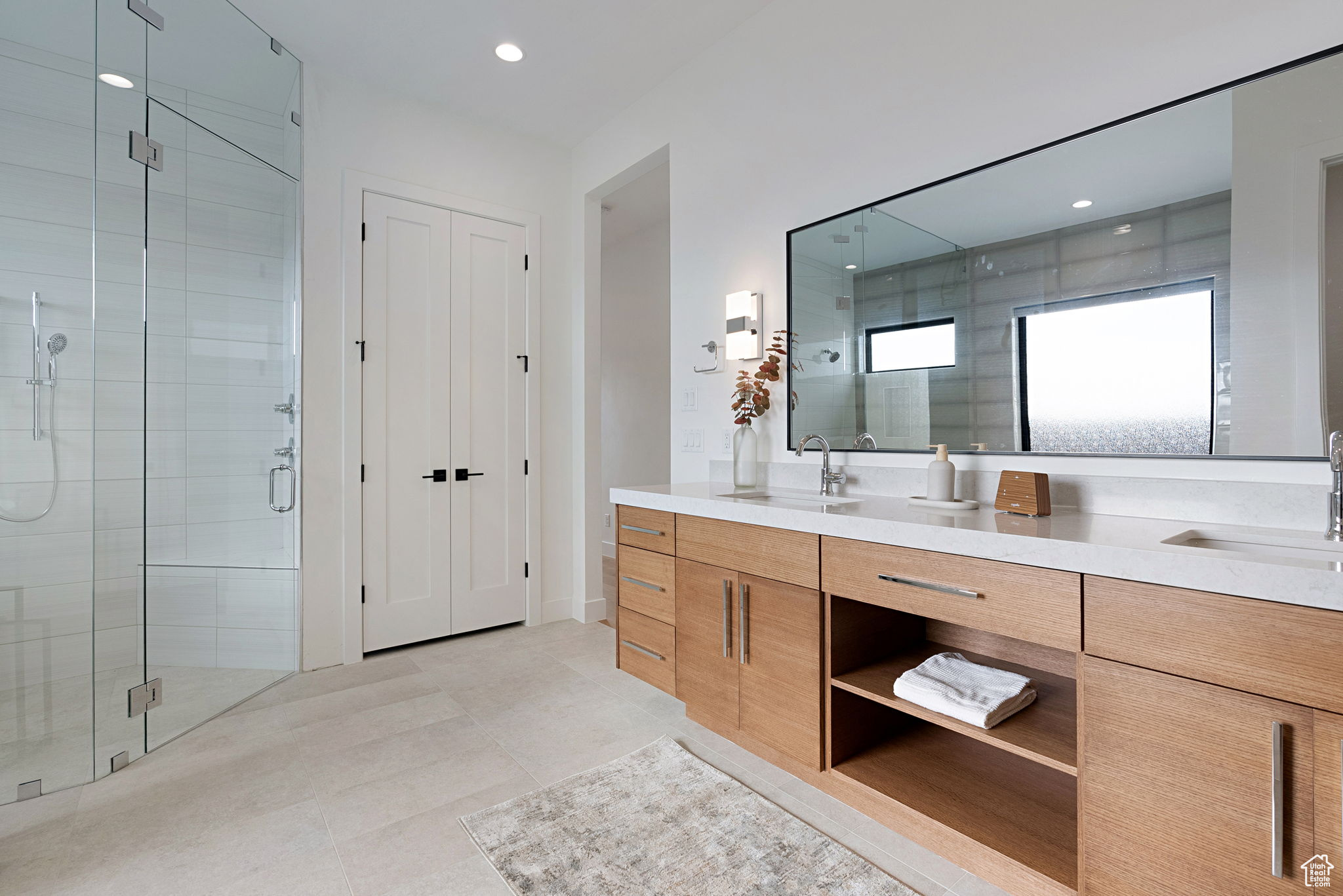 Bathroom with tile patterned flooring, vanity, and a shower with shower door