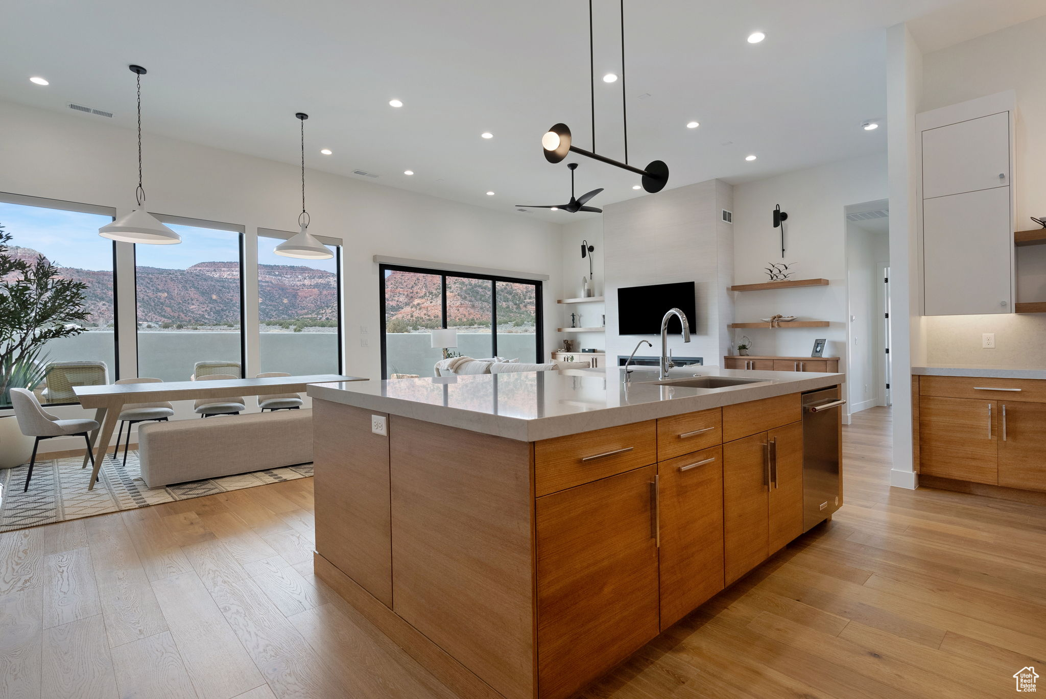 Kitchen featuring a mountain view, a large island with sink, light wood-type flooring, and sink