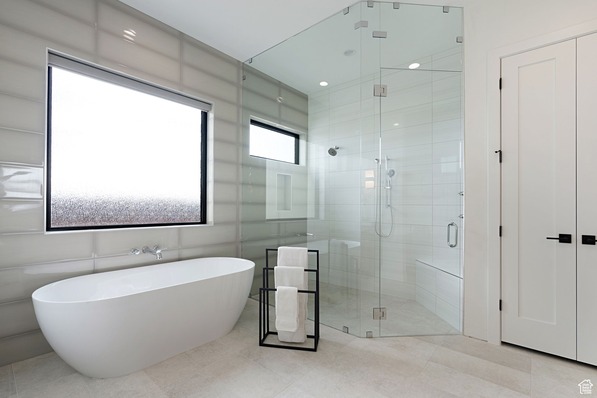 Bathroom featuring separate shower and tub and tile walls