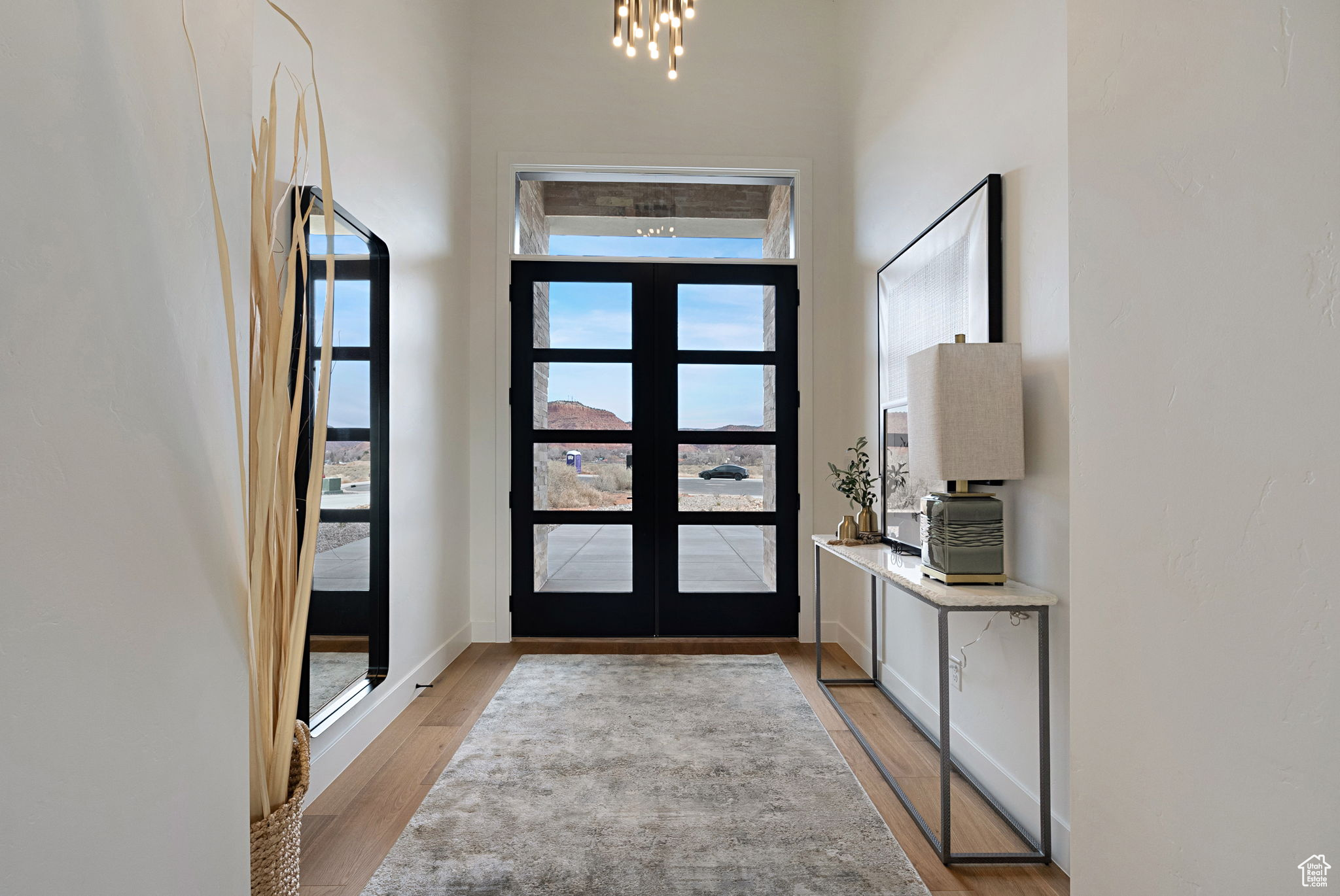 Entryway featuring french doors, a notable chandelier, and light wood-type flooring