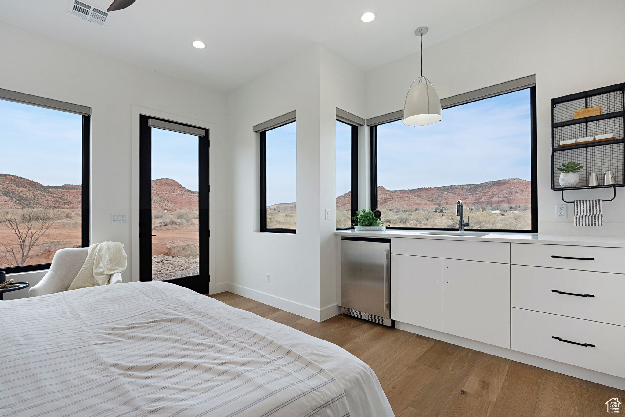 Casita with Kitchenette. Bedroom with a mountain view, light wood-type flooring, multiple windows, and fridge