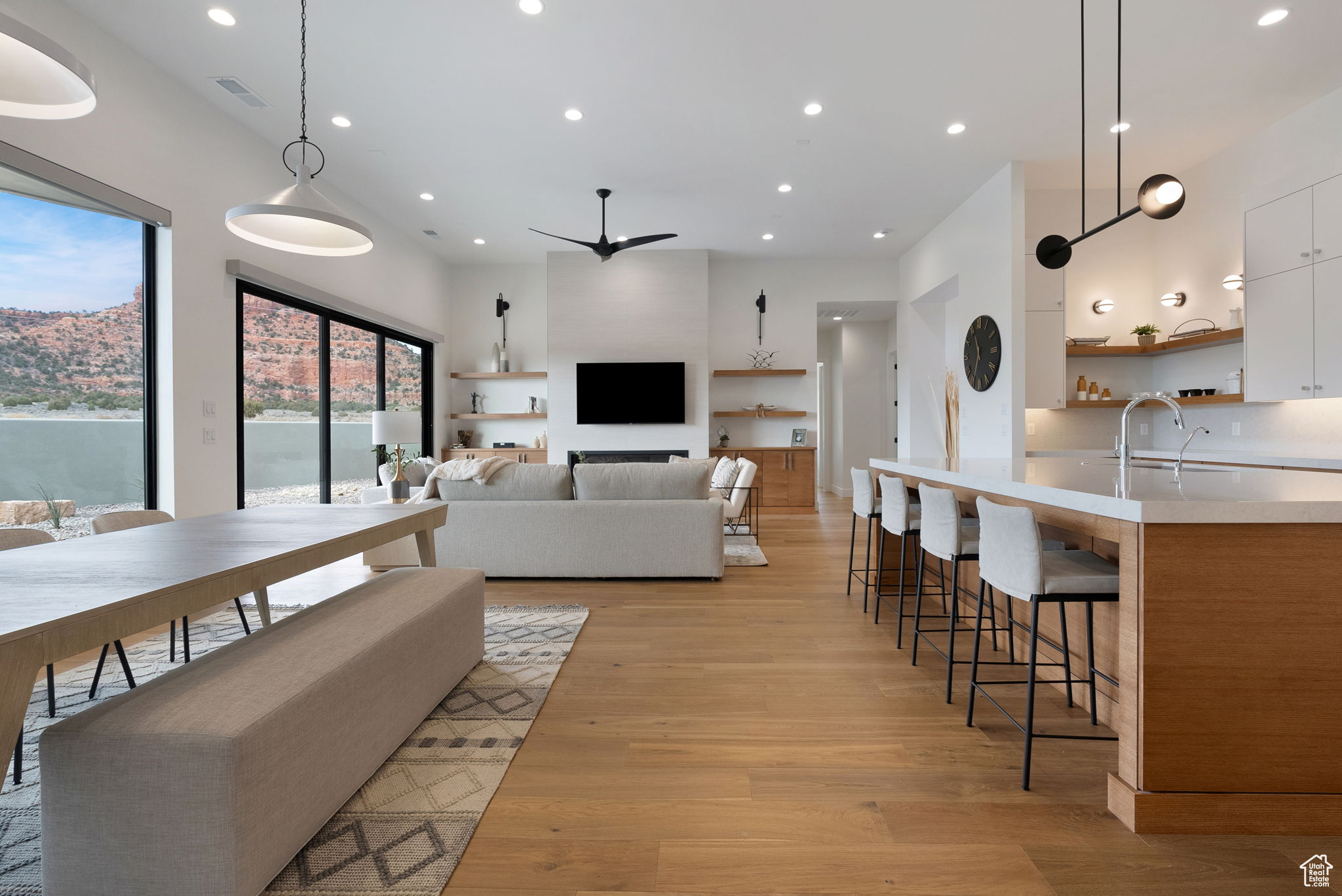 Living room with ceiling fan, sink, and light hardwood / wood-style flooring