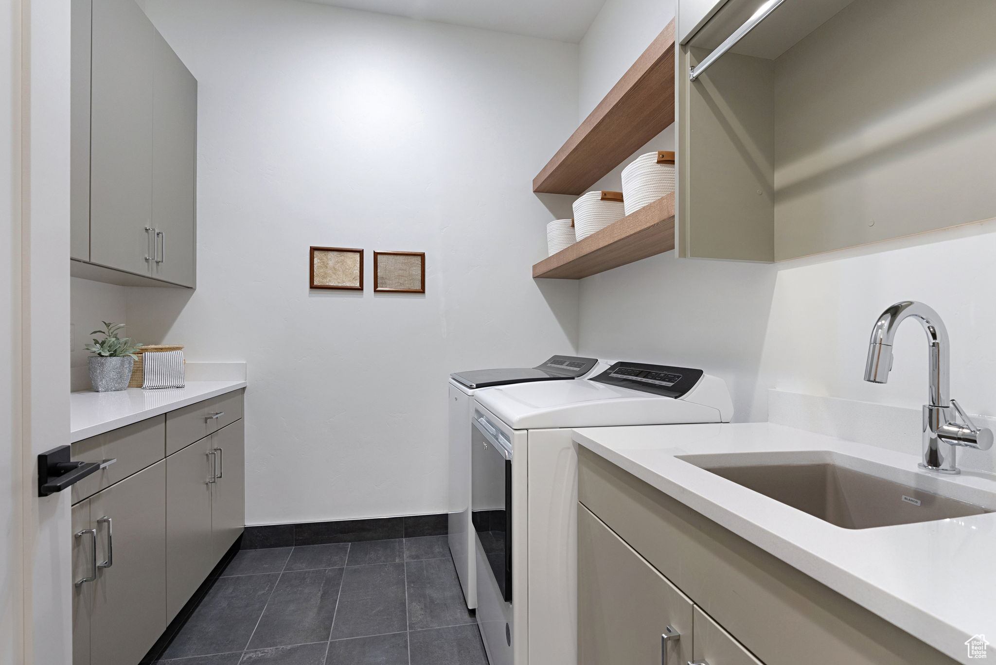 Laundry area featuring washer and dryer, cabinets, and sink