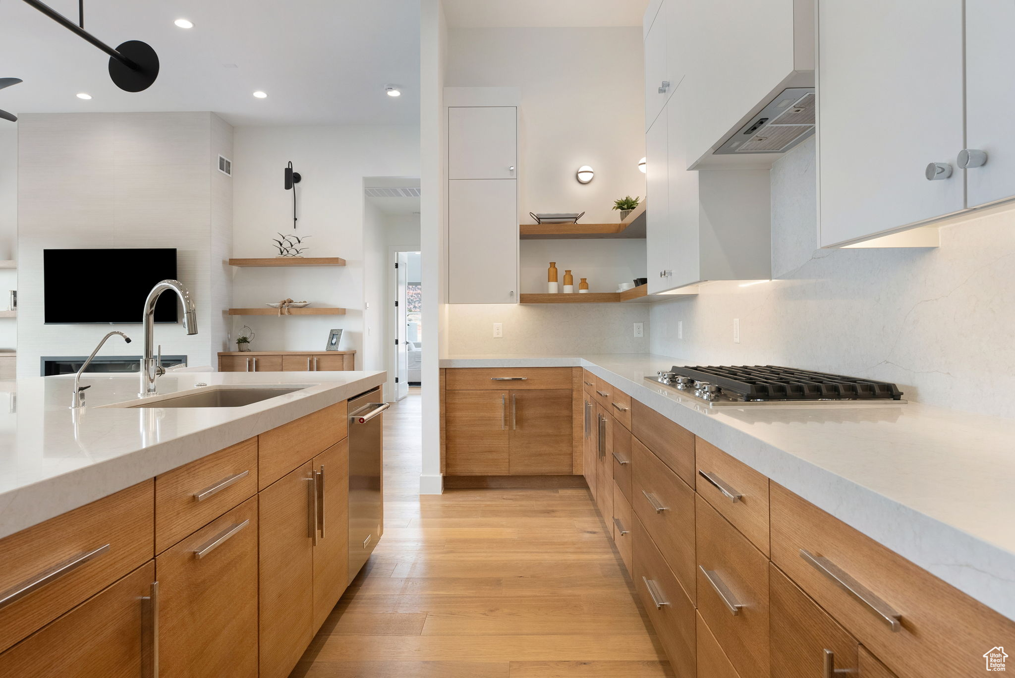 Kitchen featuring white cabinetry, sink, stainless steel appliances, exhaust hood, and light wood-type flooring