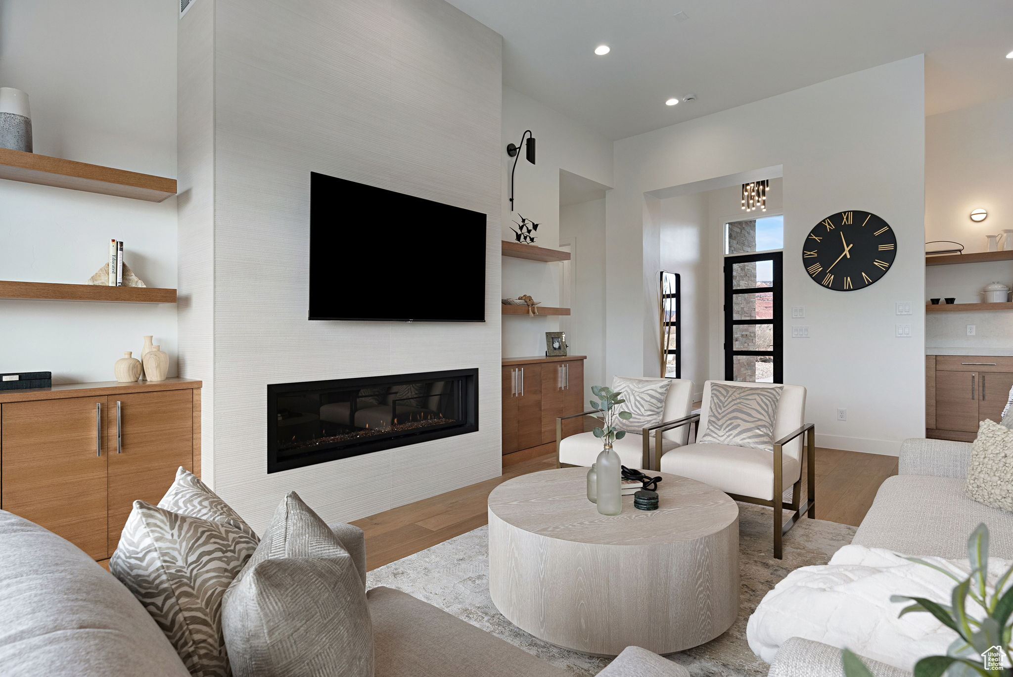 Living room with a fireplace and light hardwood / wood-style floors