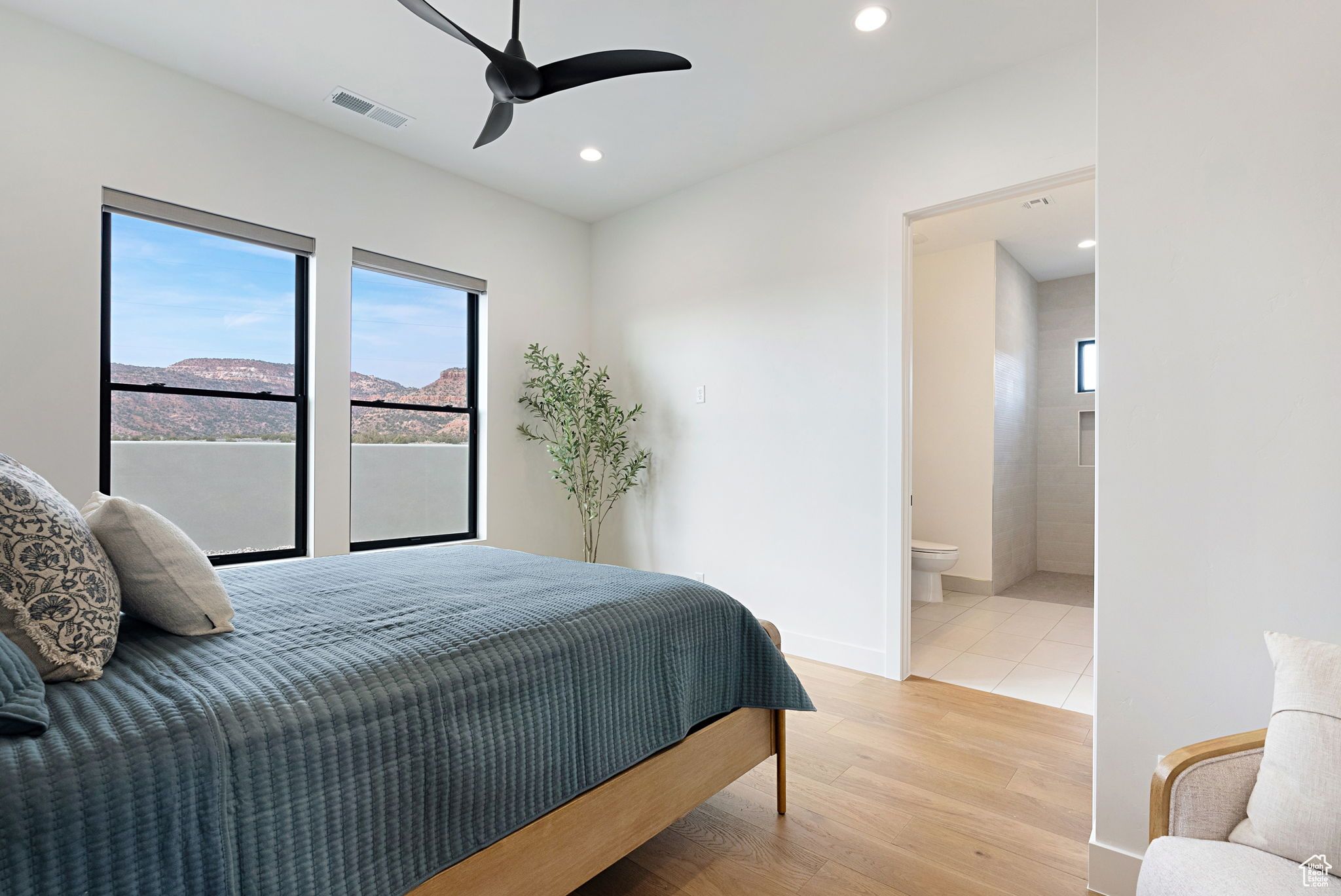 En-Suite Bedroom with a mountain view, light hardwood / wood-style floors, ceiling fan, and ensuite bathroom