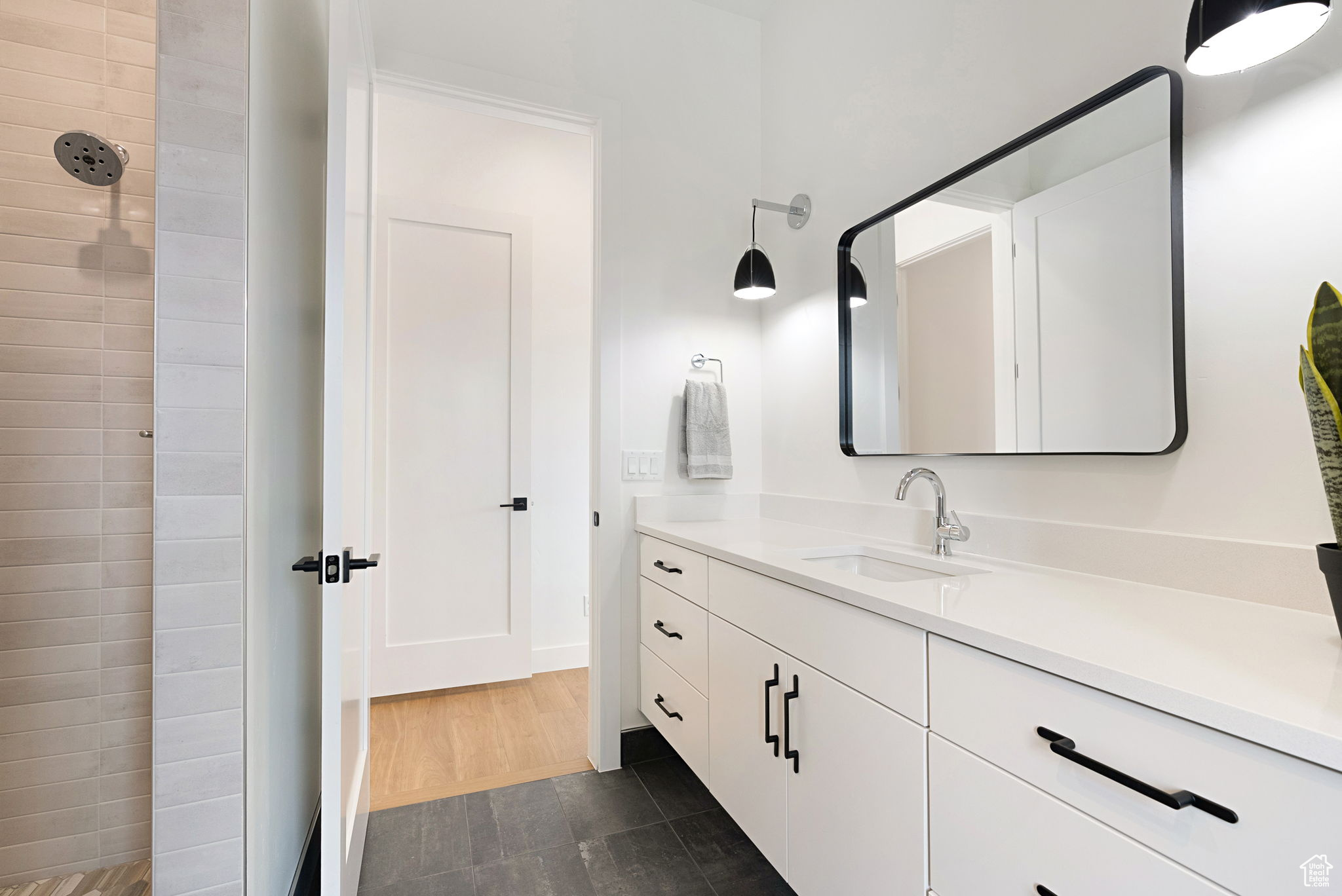 Casita Bathroom.Bathroom featuring a tile shower, vanity, and wood-type flooring