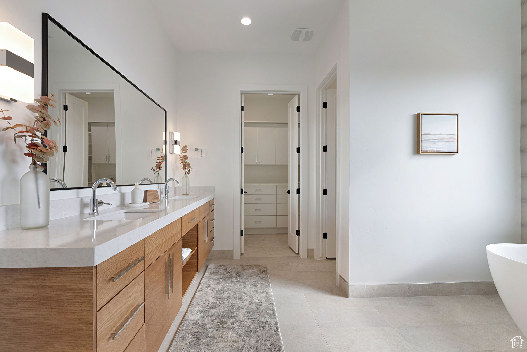 Bathroom featuring a washtub, vanity, and tile patterned flooring