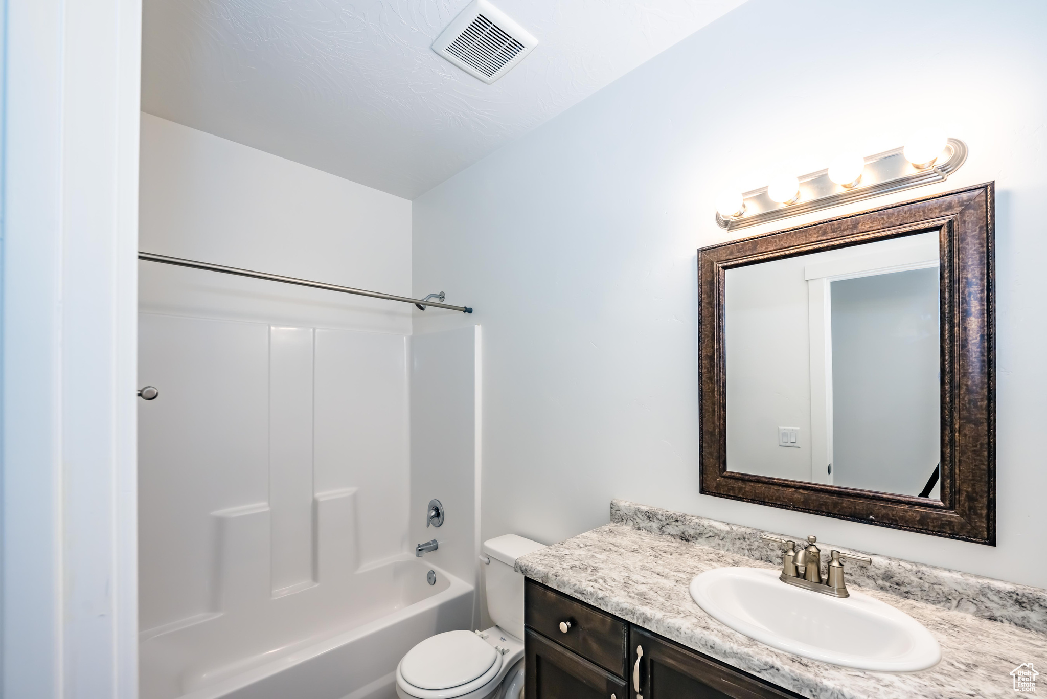 Full bathroom featuring vanity,  shower combination, and toilet