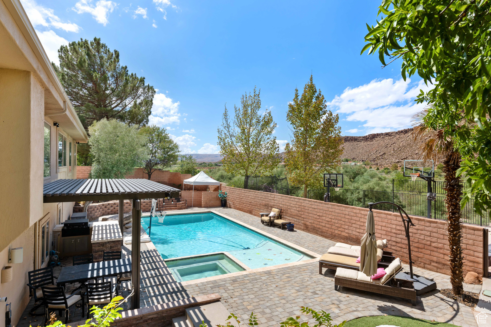 View of swimming pool with an in ground hot tub, a mountain view, and a patio