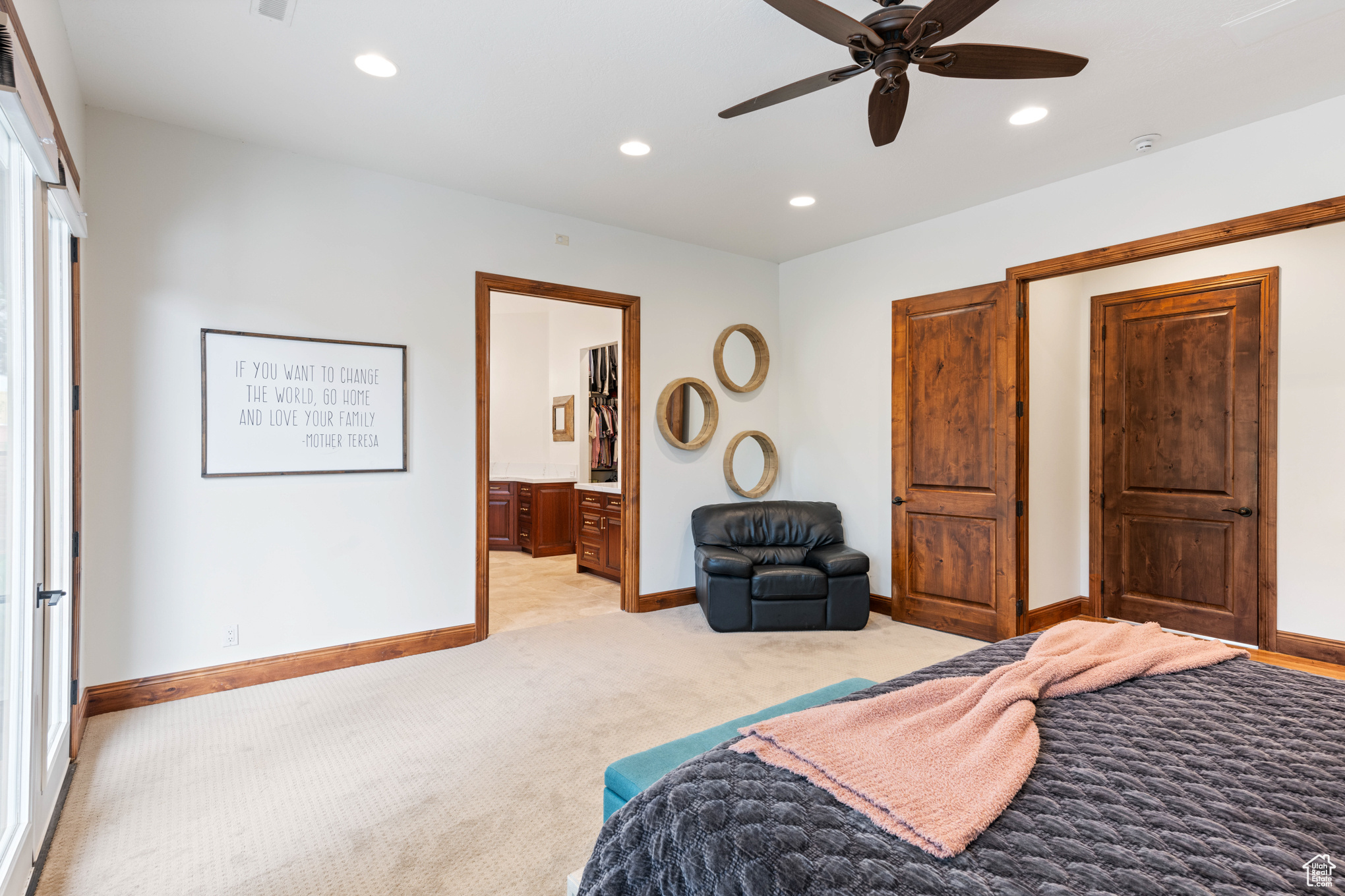 Carpeted bedroom featuring connected bathroom and ceiling fan