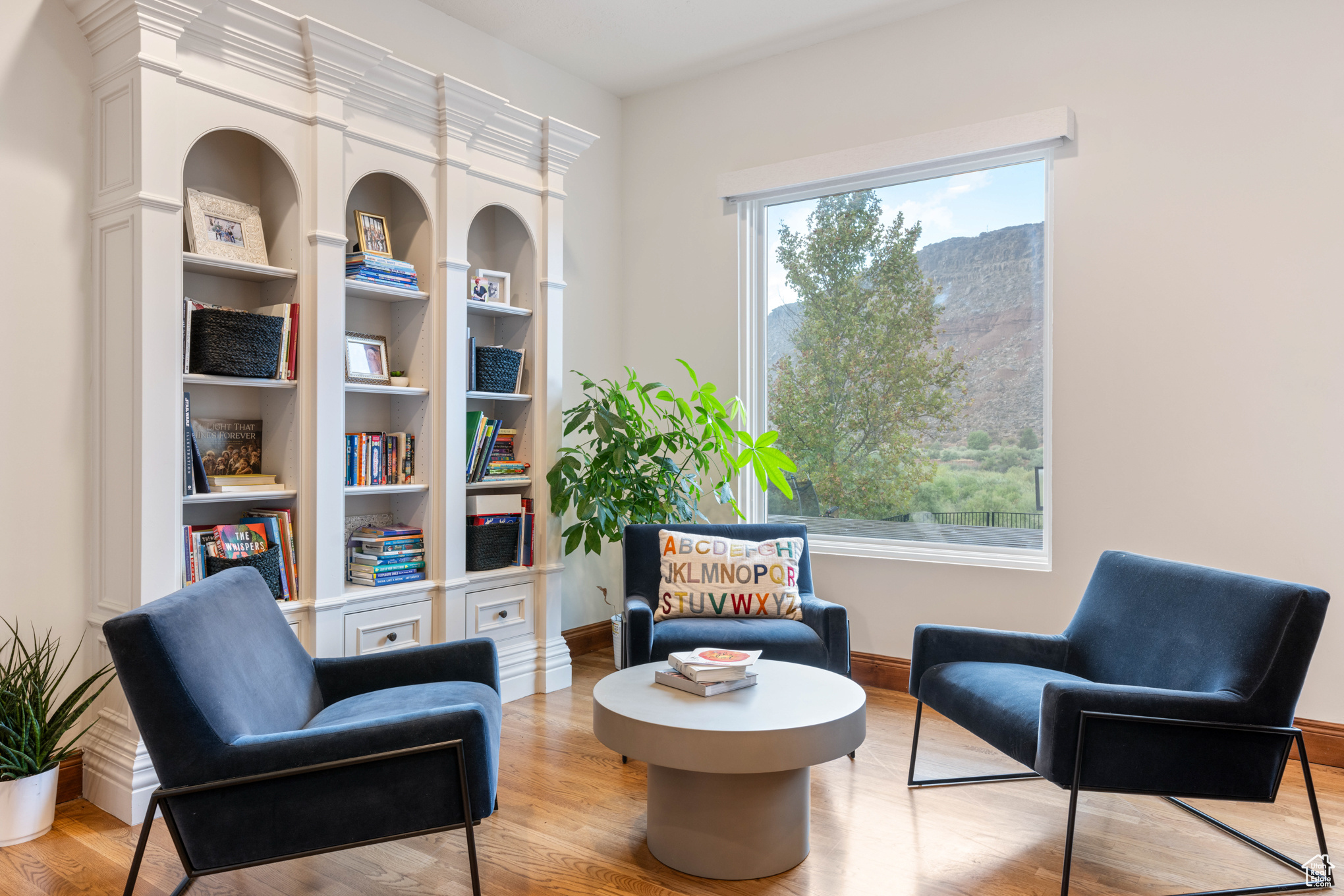 Living area featuring plenty of natural light, built in features, and light hardwood / wood-style flooring